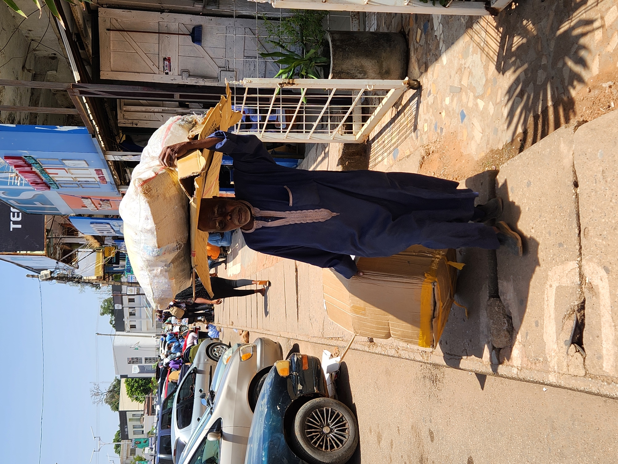 Man carries goods through Jos market area