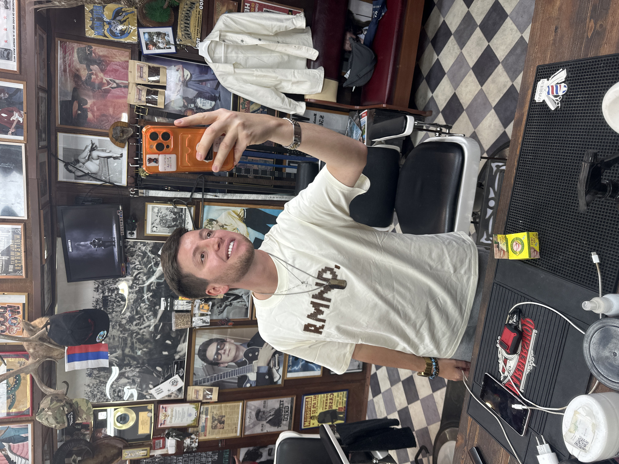 Man documents barbershop visit with selfies in cluttered Moscow establishment