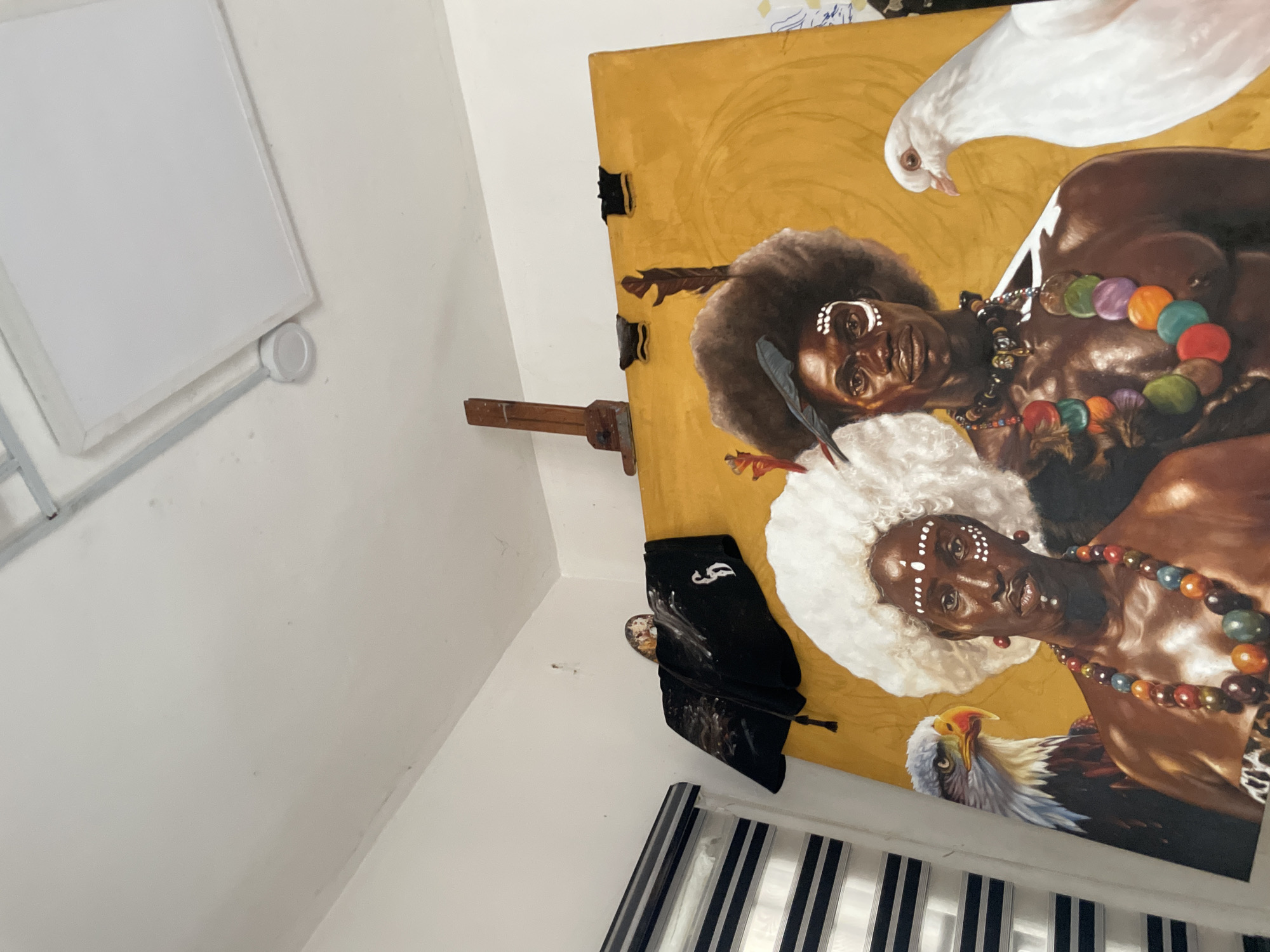 Artist workspace with traditional portrait painting observed in Ado