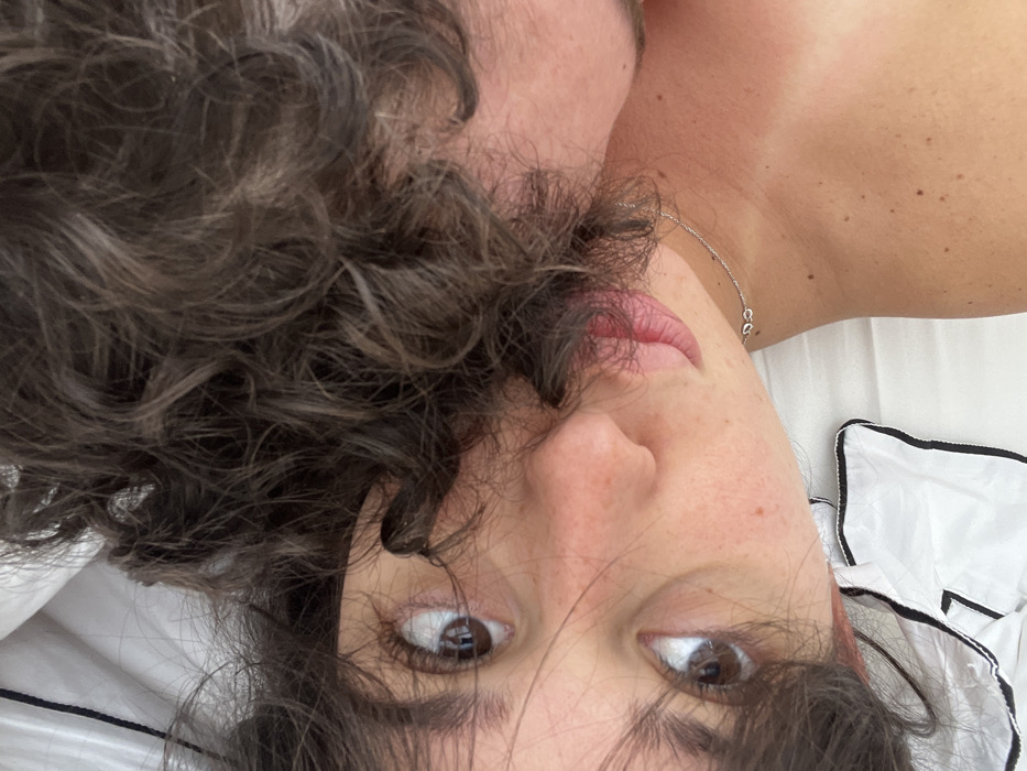 Person with curly hair photographed resting indoors in Milan