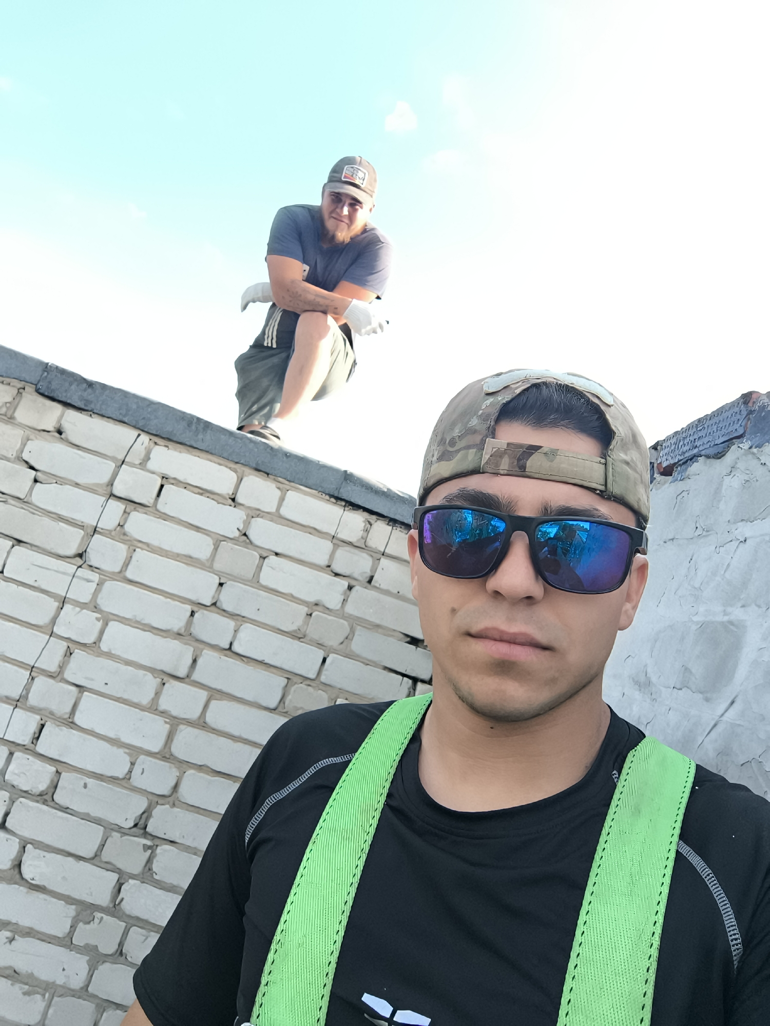 Two men spotted on rooftop wearing safety gear