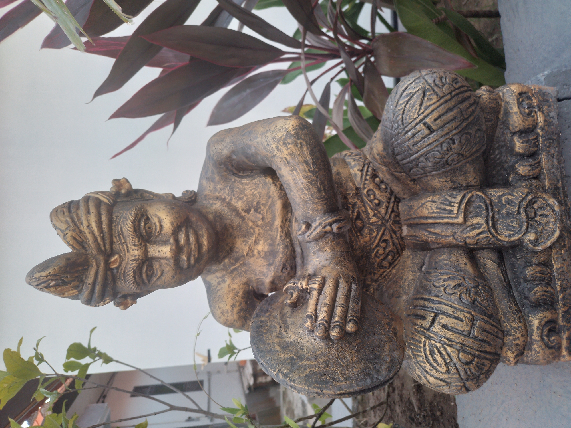 Ornate statue documented amid tropical foliage in Kuta Selatan