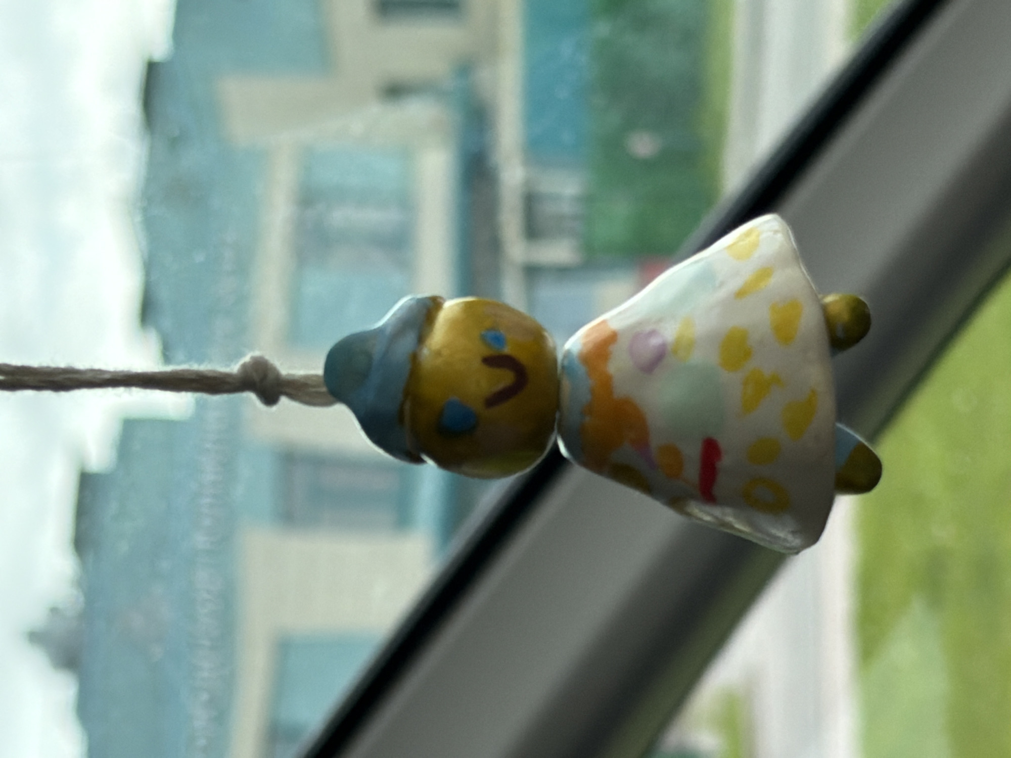 Handmade clay figurine hangs as car decoration in Strelna