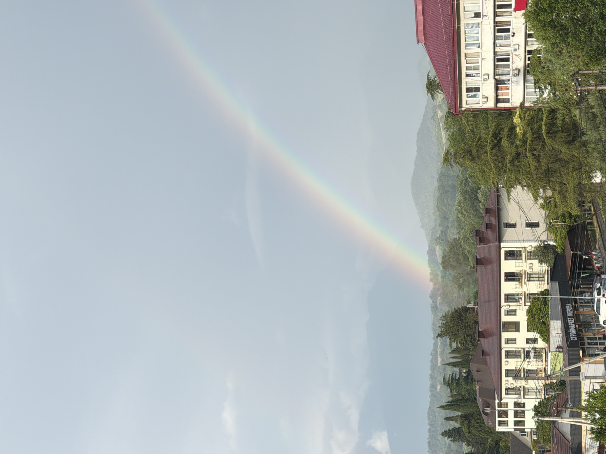 Rainbow over Sochi skyline with mountain backdrop