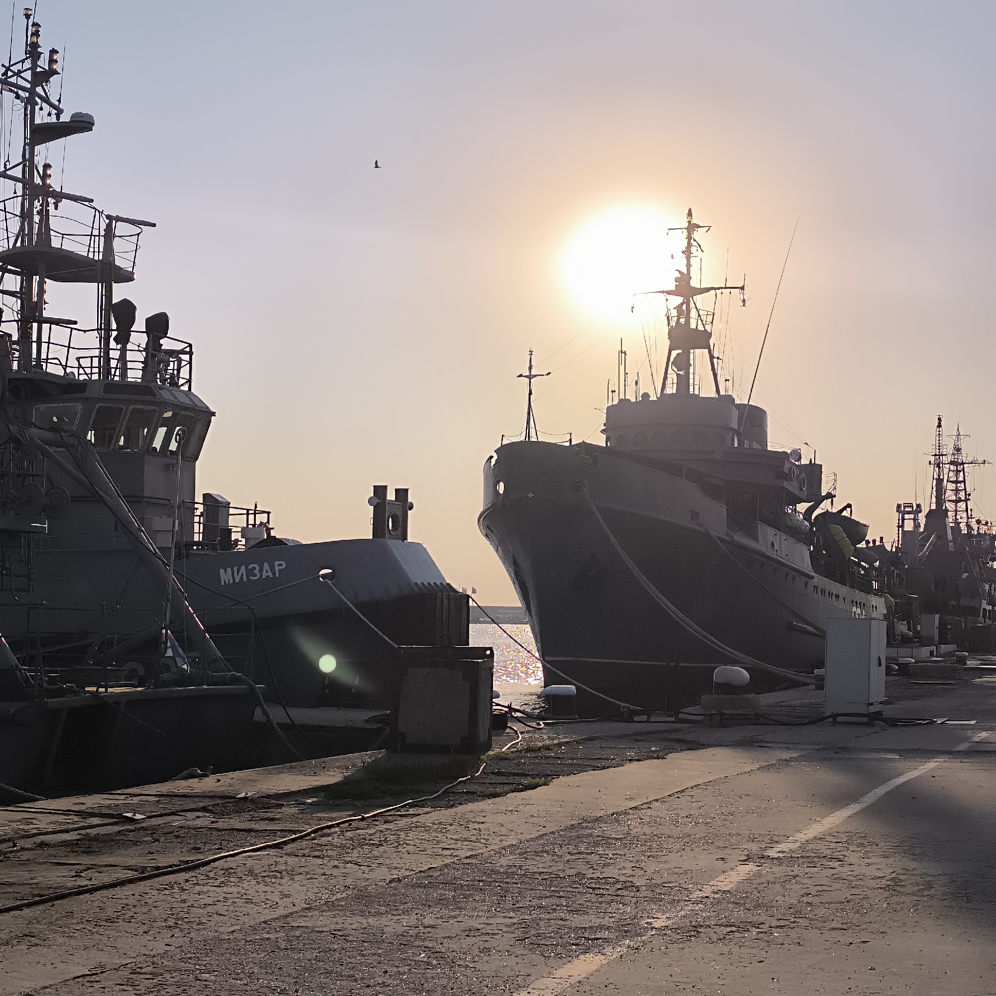 Naval vessels docked at golden hour in Varna harbor