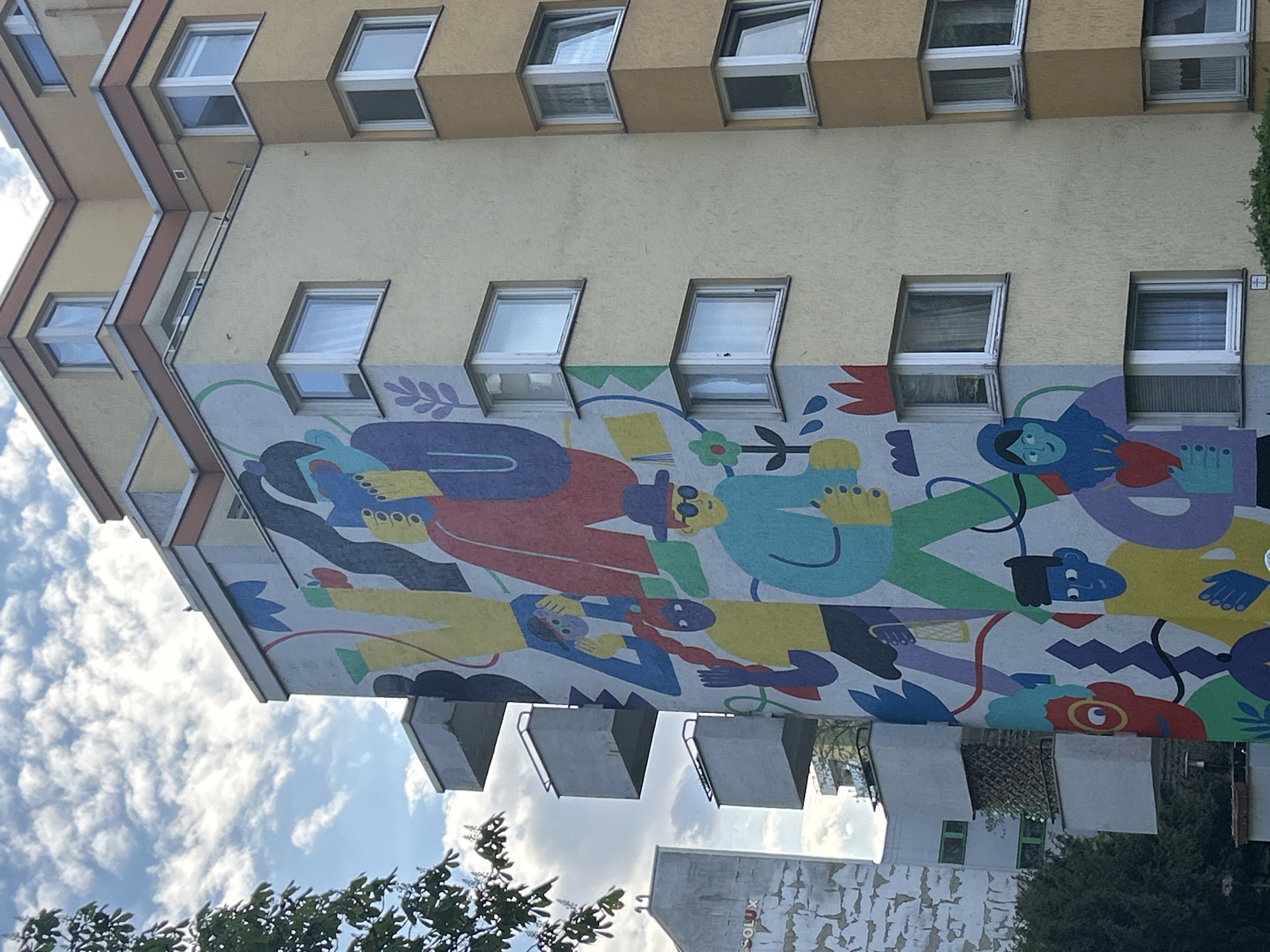 Multi-story building with colorful mural documented by witness