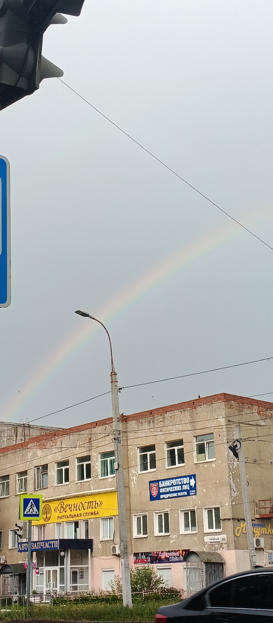 Double rainbow over Izhevsk streets on a cloudy afternoon