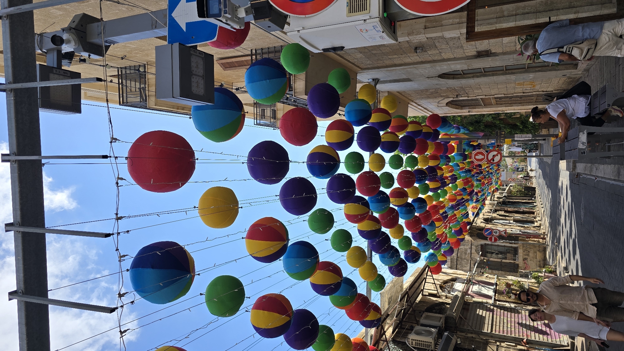 Colorful balloon canopy decorates a sunny Tel Aviv street