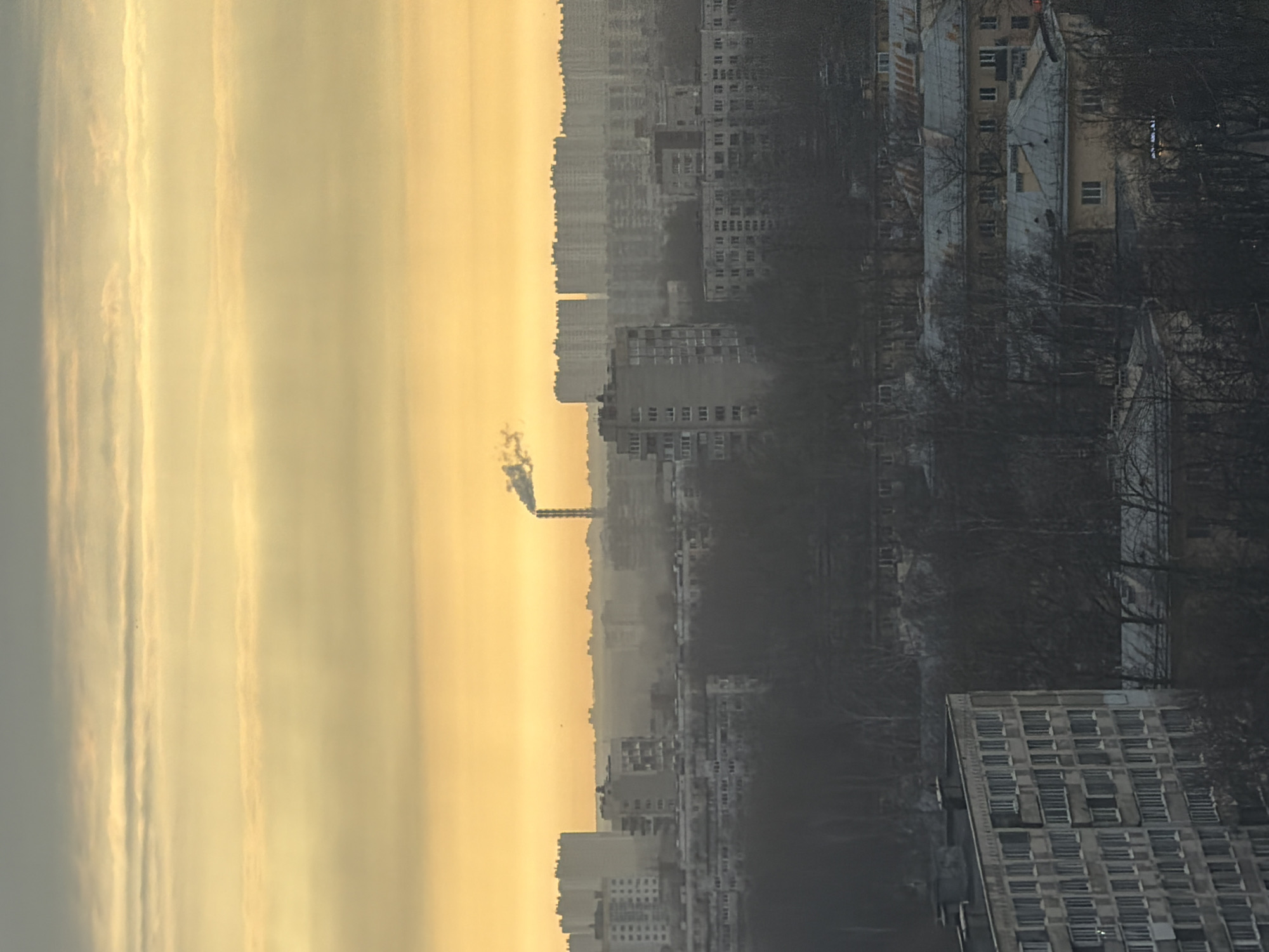 Industrial smokestack emits smoke over Saint Petersburg at dawn