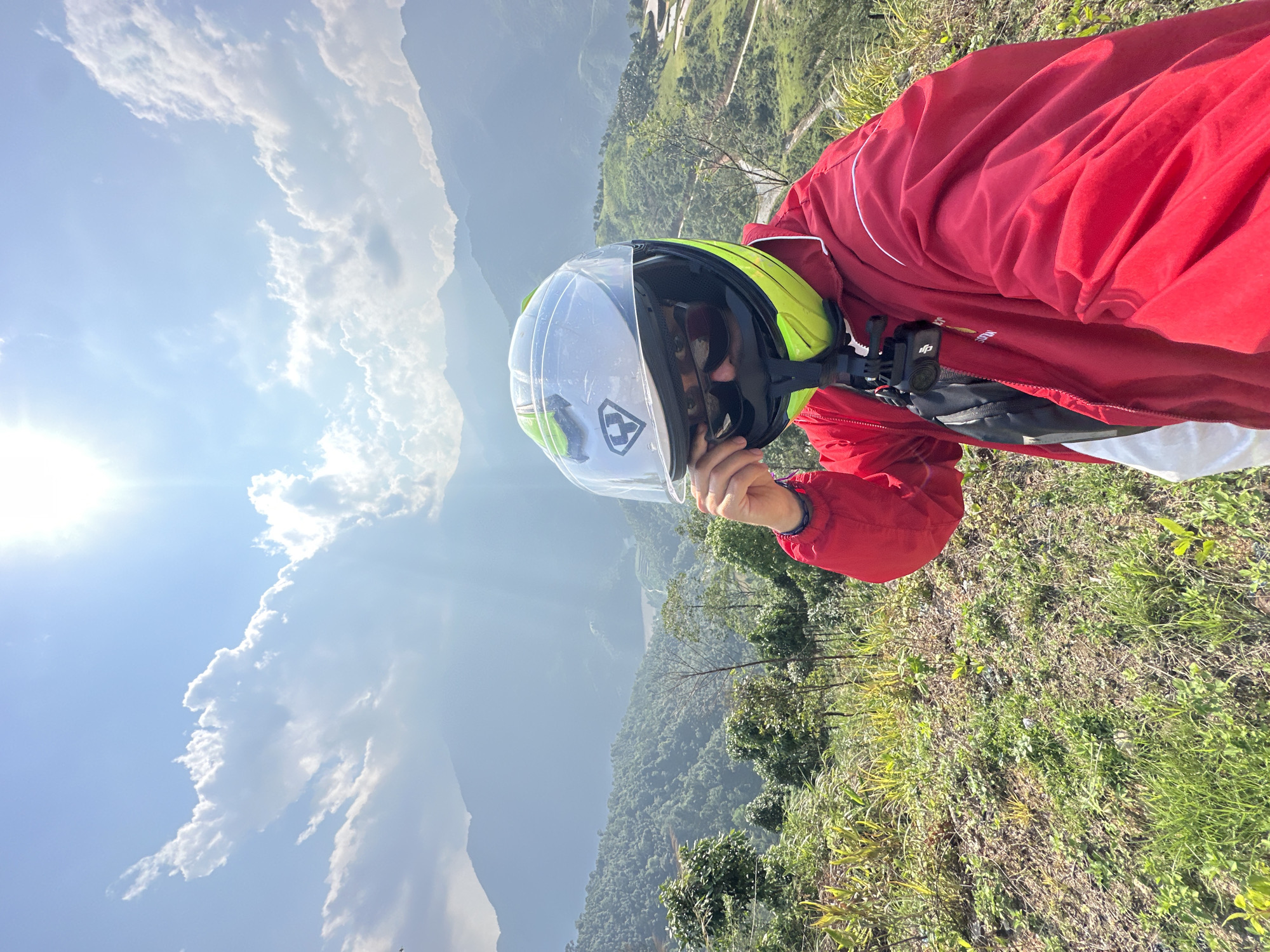 Motorcyclist pauses in Vietnam's terraced mountain landscape