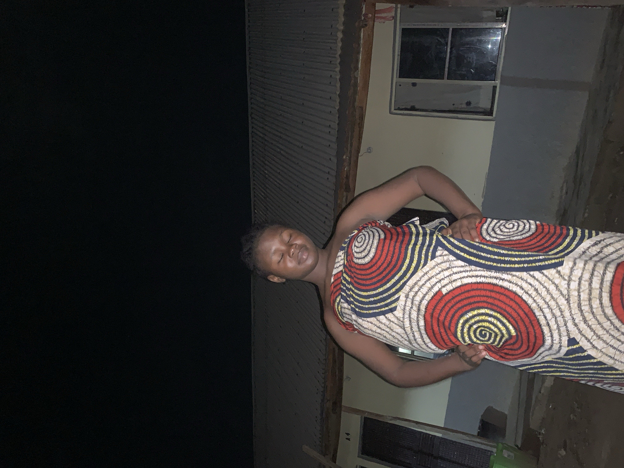 Person in patterned dress observed outside Keffi building at night
