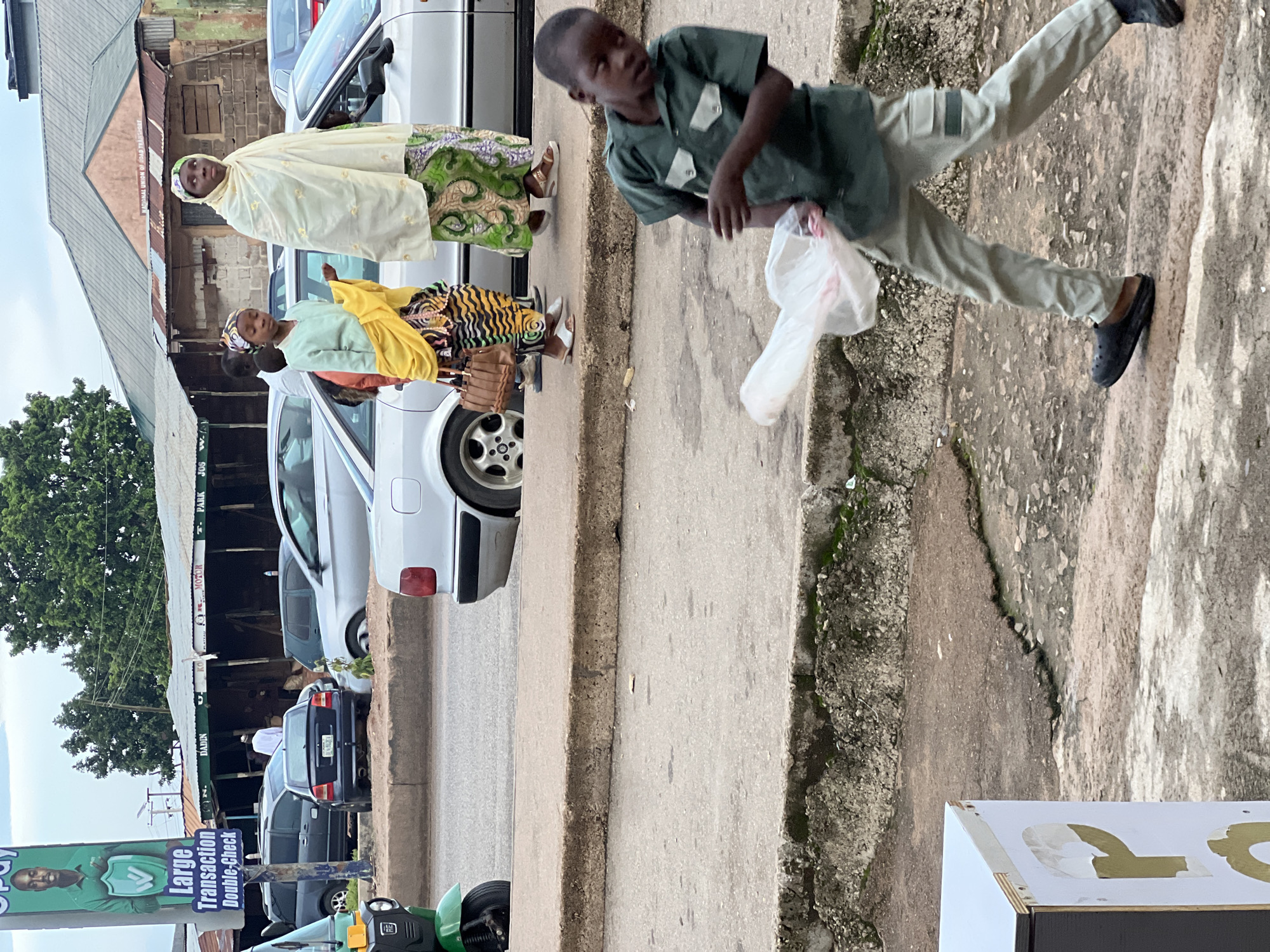Street activity near a silver SUV, including armed presence