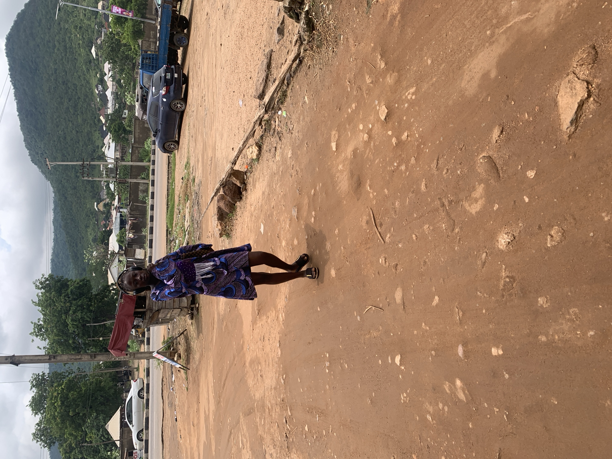 Everyday street life along a rough road in Adankolo, Nigeria