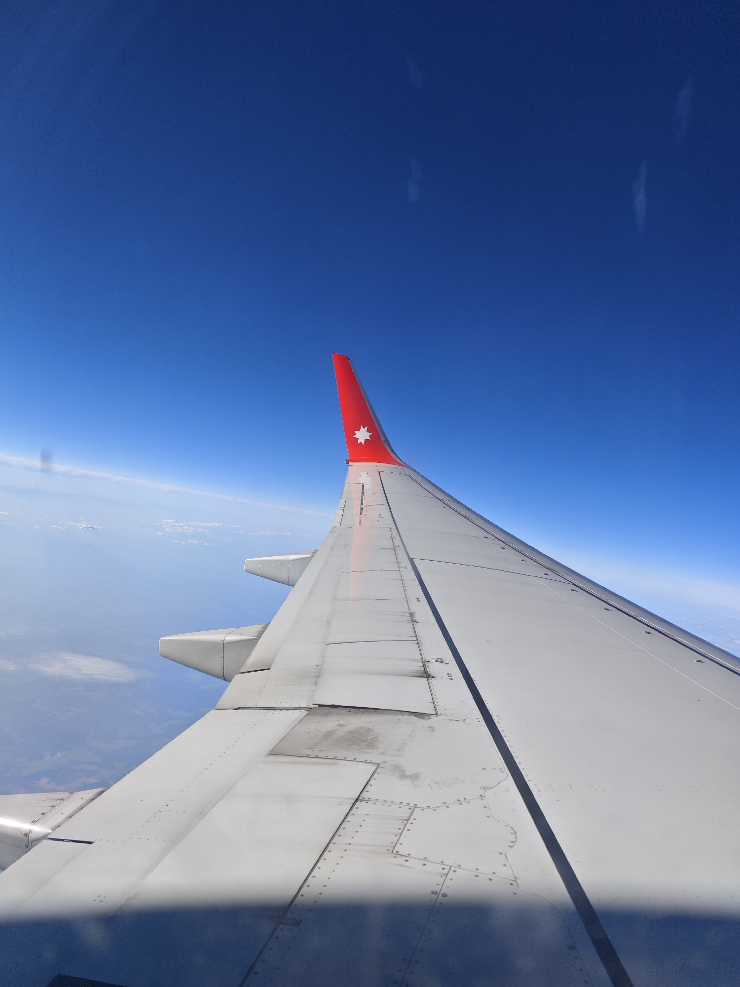 Passengers document aerial views during commercial flight over water