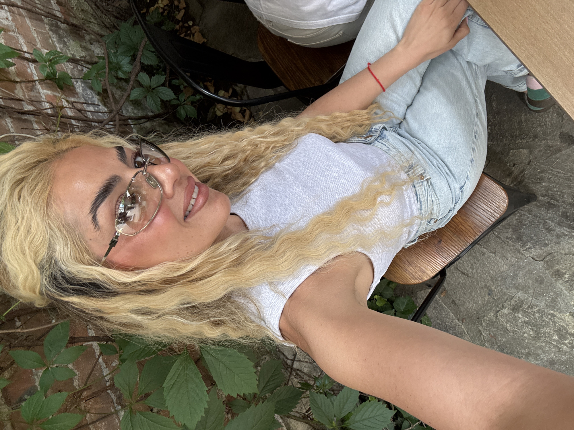 Woman Takes Multiple Mirror Selfies Near Urban Restaurant