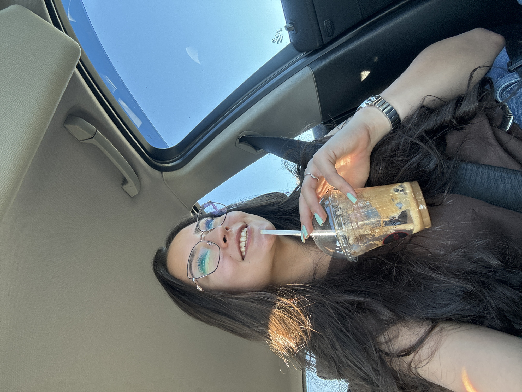 Woman drinks beverage in car with open sunroof in Piperevo