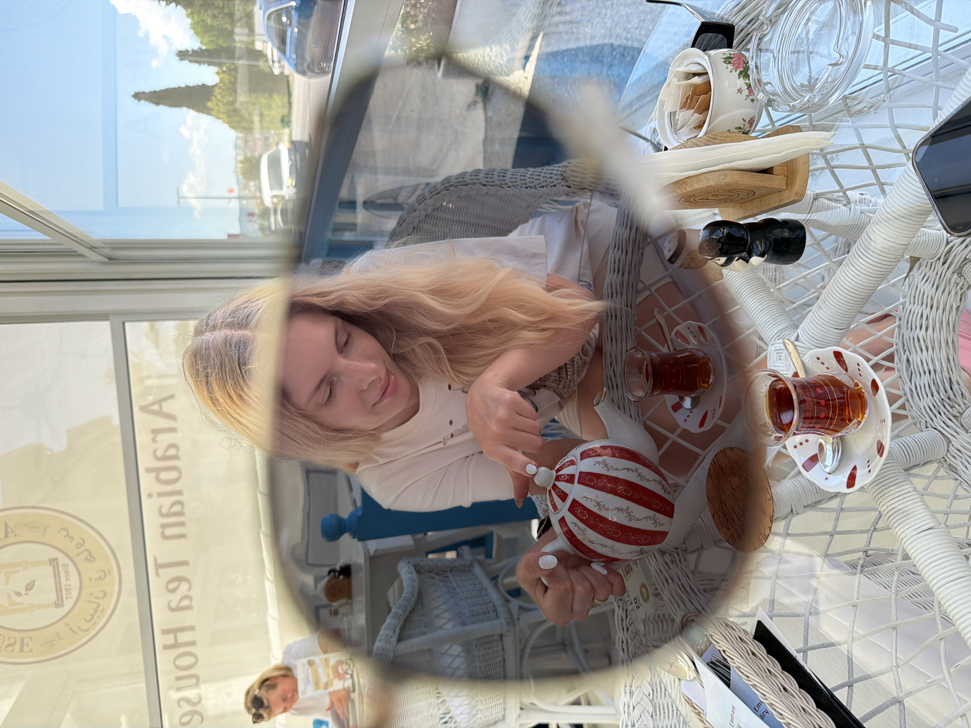 Woman enjoys tea and ceramic figurines at Podgorica cafe