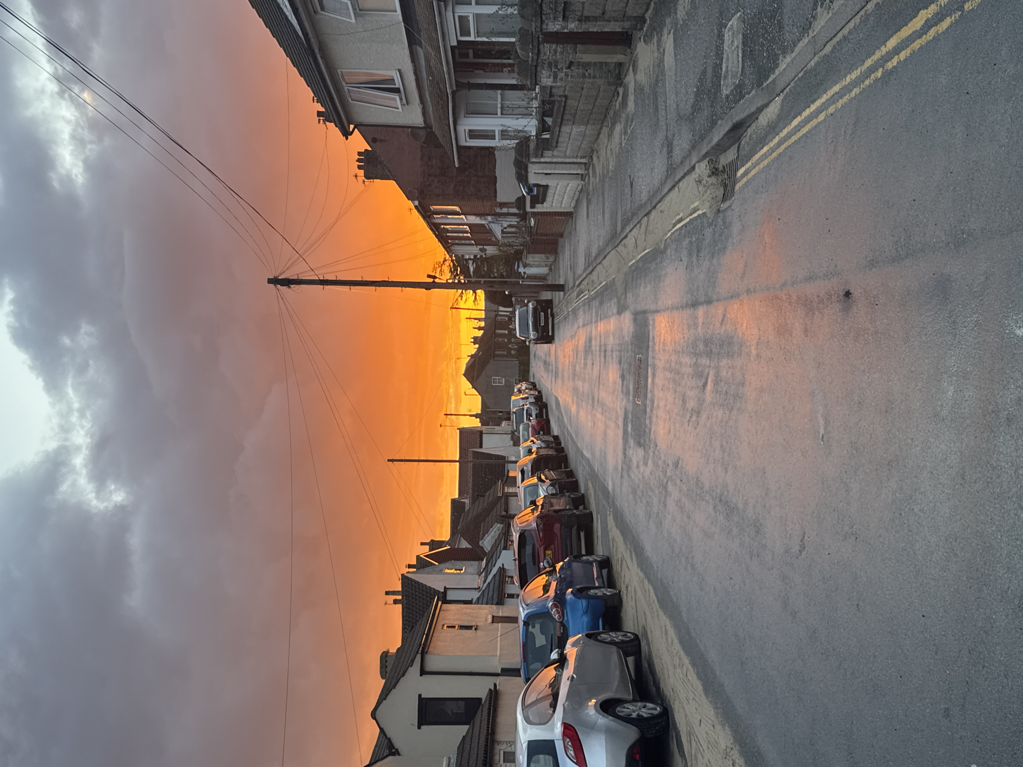 Dramatic orange sunset illuminates Caister-on-Sea streets and beach