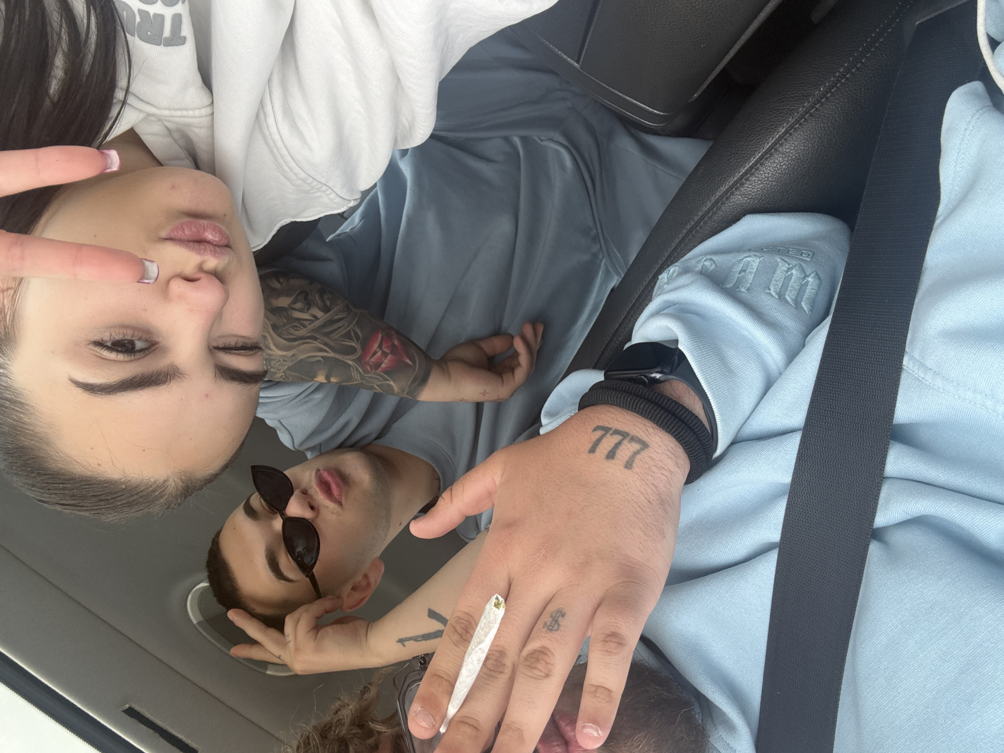 Three friends photographed together inside car in Belo Pole