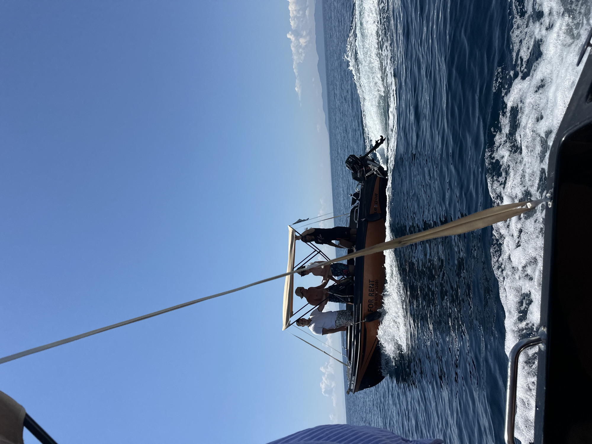 Small orange boat out on the Greek sea on a clear day