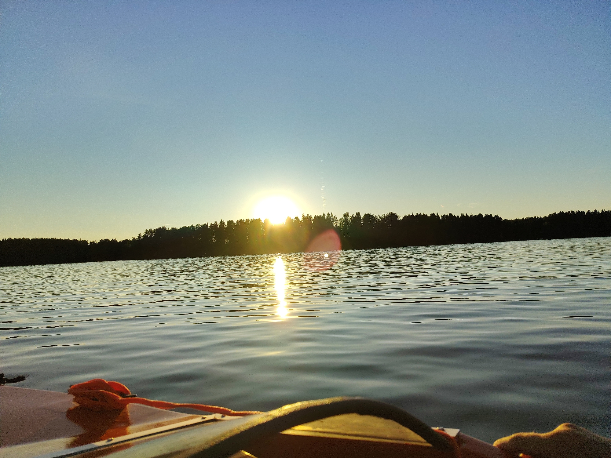 Golden sunset reflects across still water at dusk.