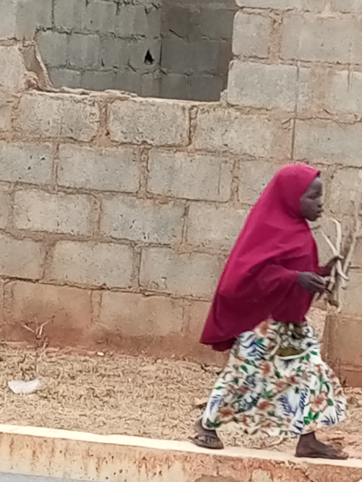 Everyday activity around a brick building and outdoor marketplace