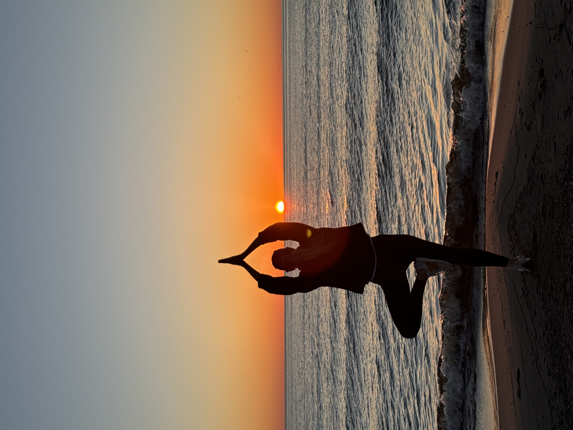 Evening yoga session captured on Latvian beach at sunset