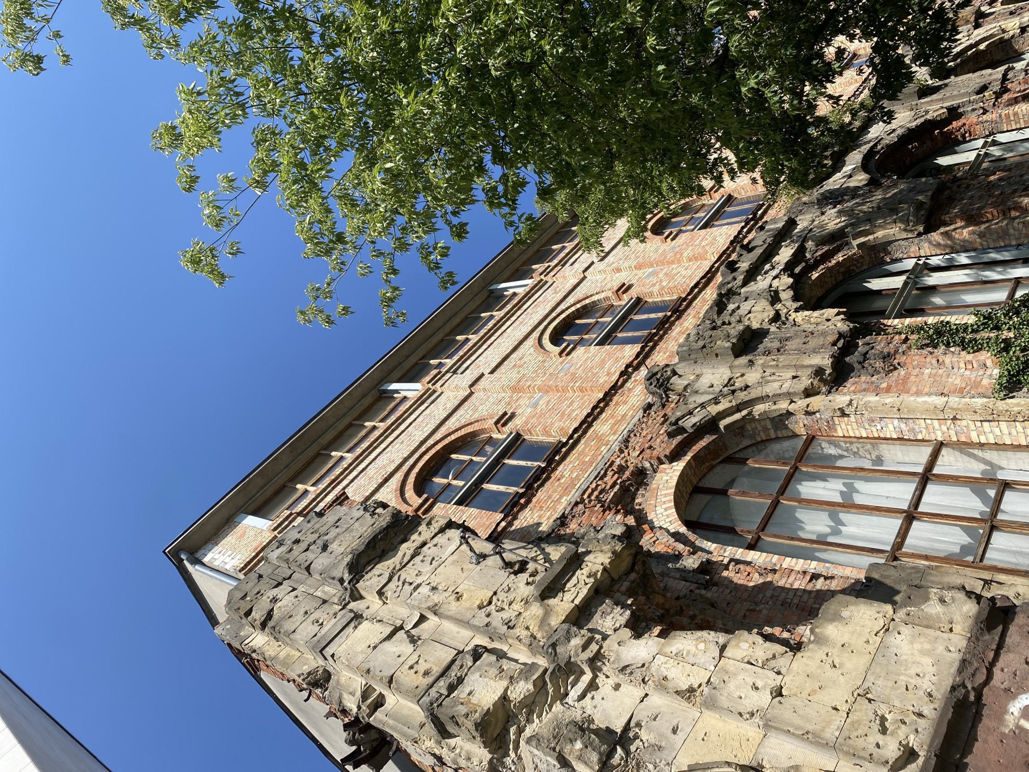 Scarred brick building in Warsaw, history written on its walls