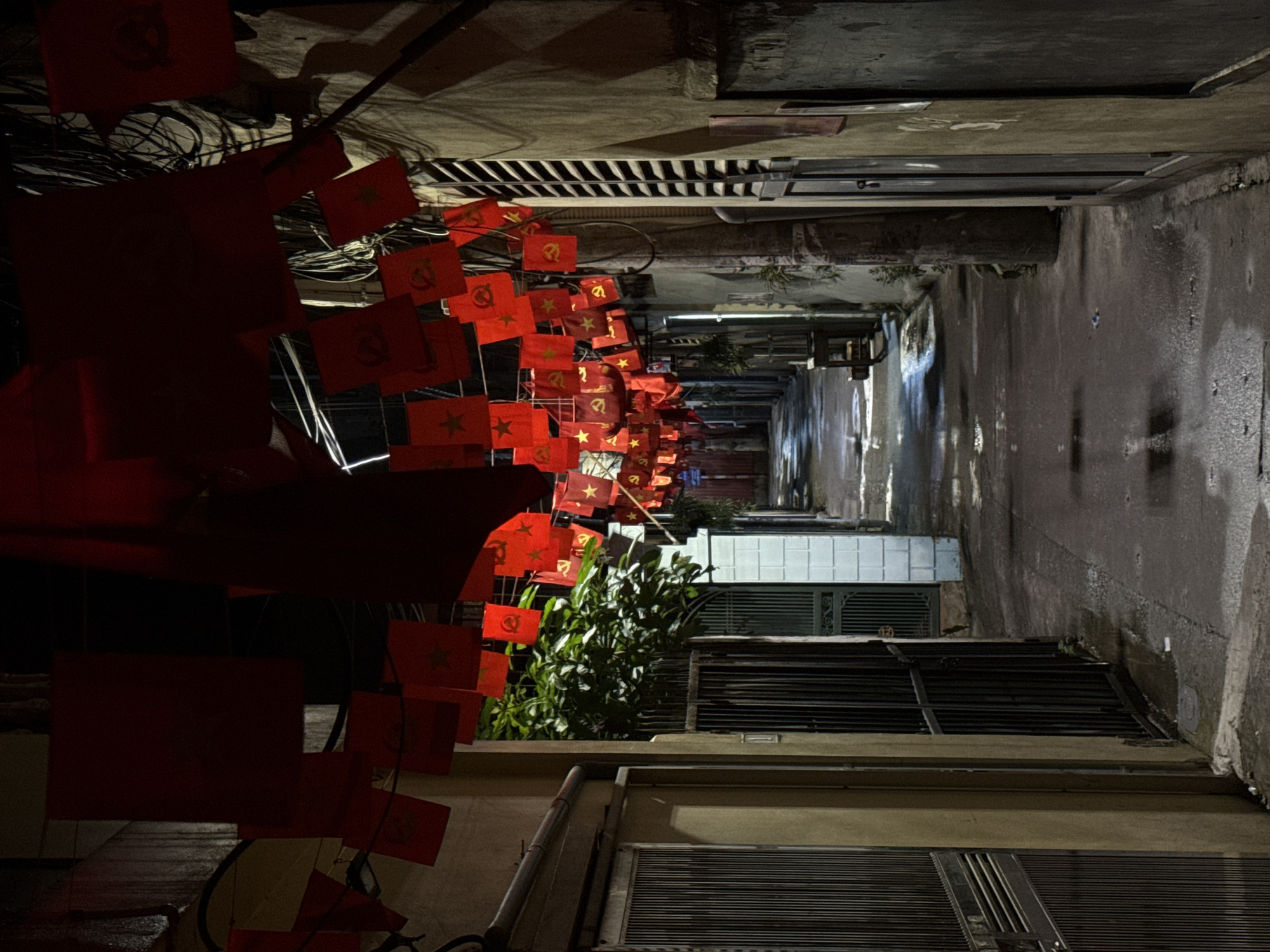 Communist flags decorate narrow Hanoi alleyway