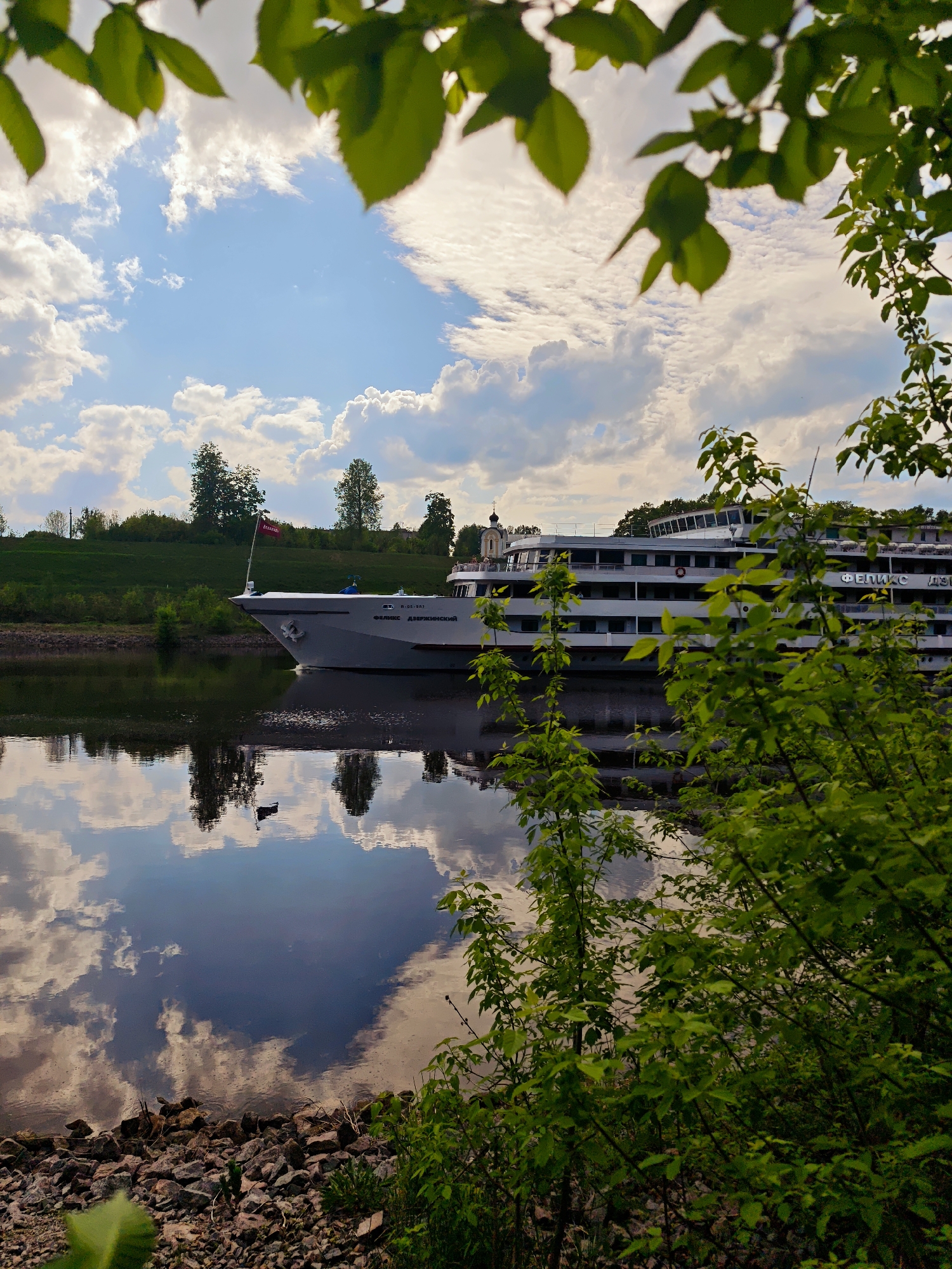 Cruise ship sails past neoclassical building in Russian town