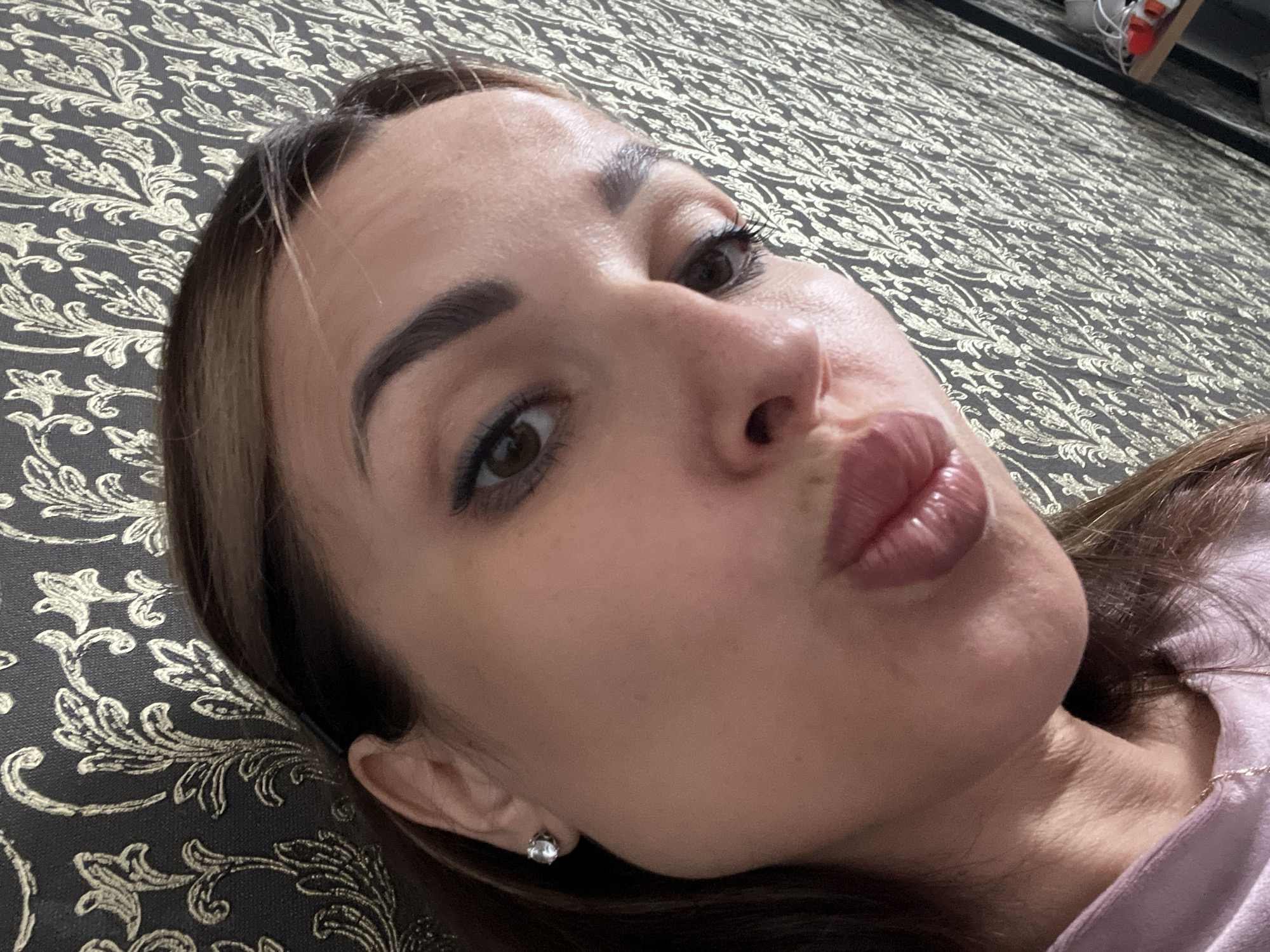 Casual selfie session on a patterned sofa with gold wallpaper