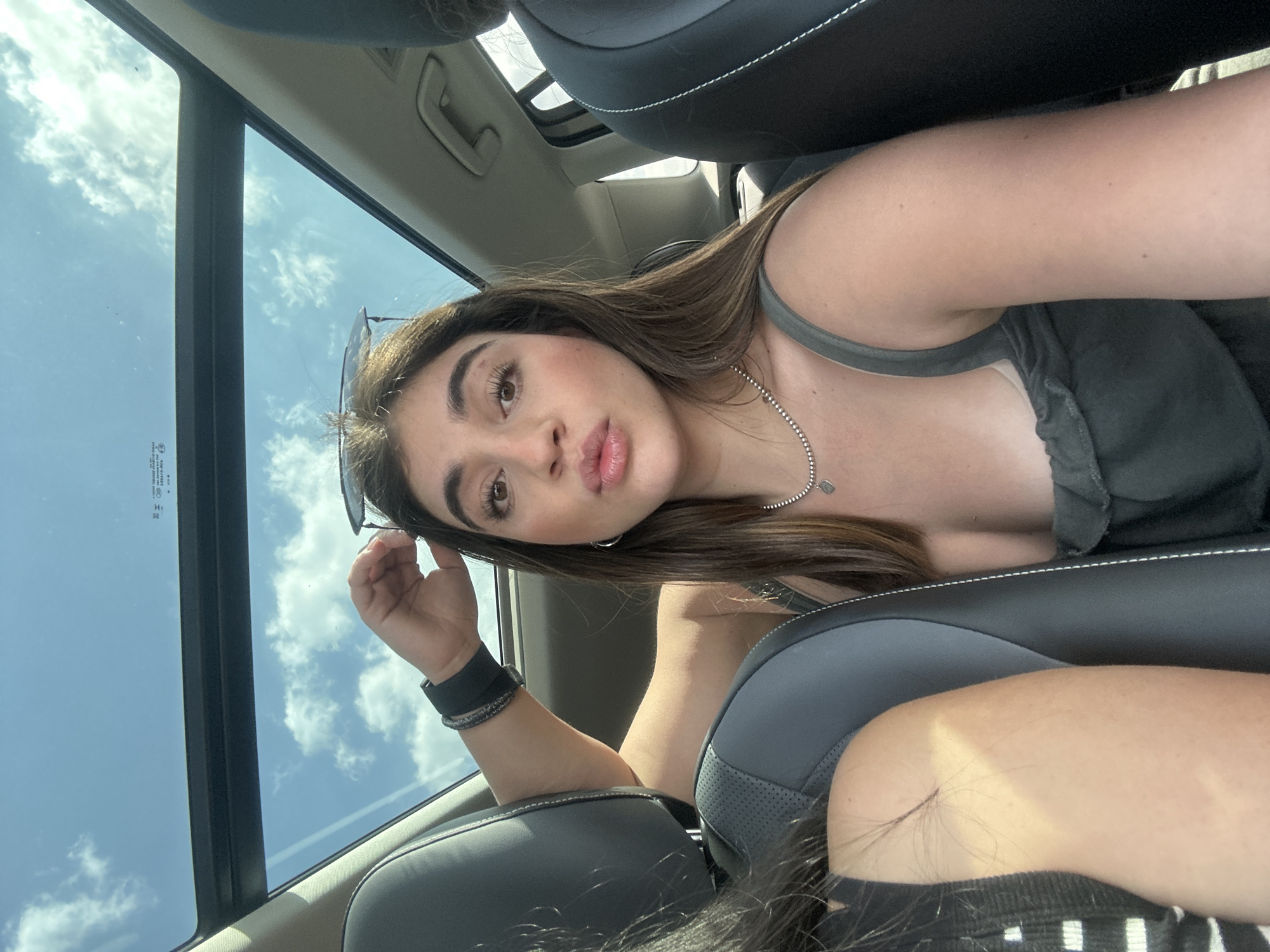 Young women take selfies in car with sunroof in Mexico City