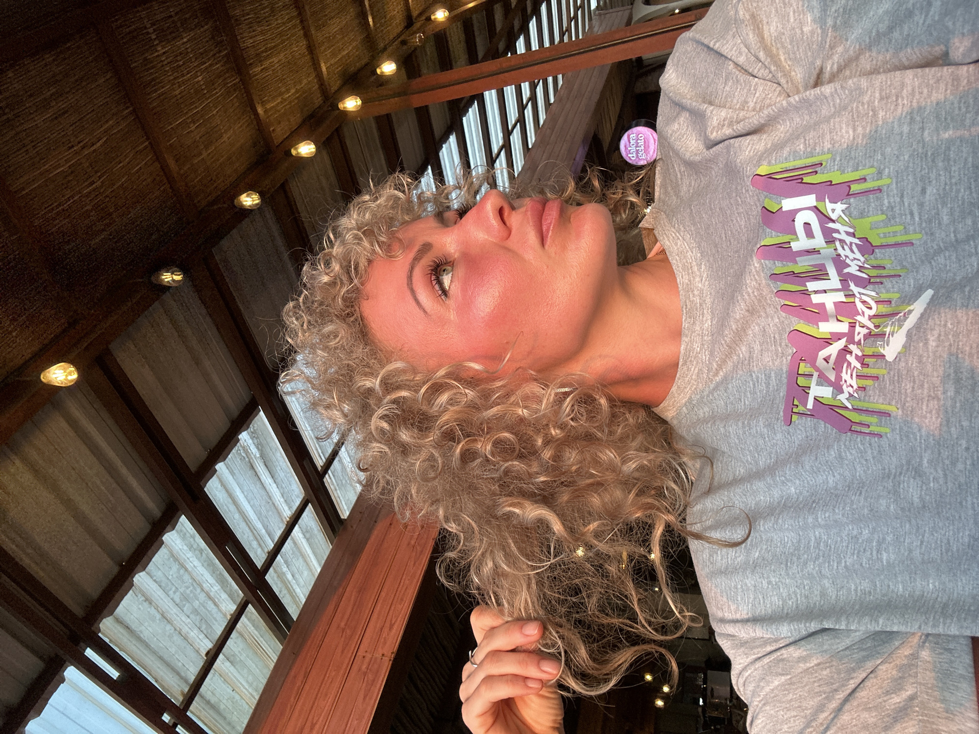 Blonde woman captured in golden light, looking upward
