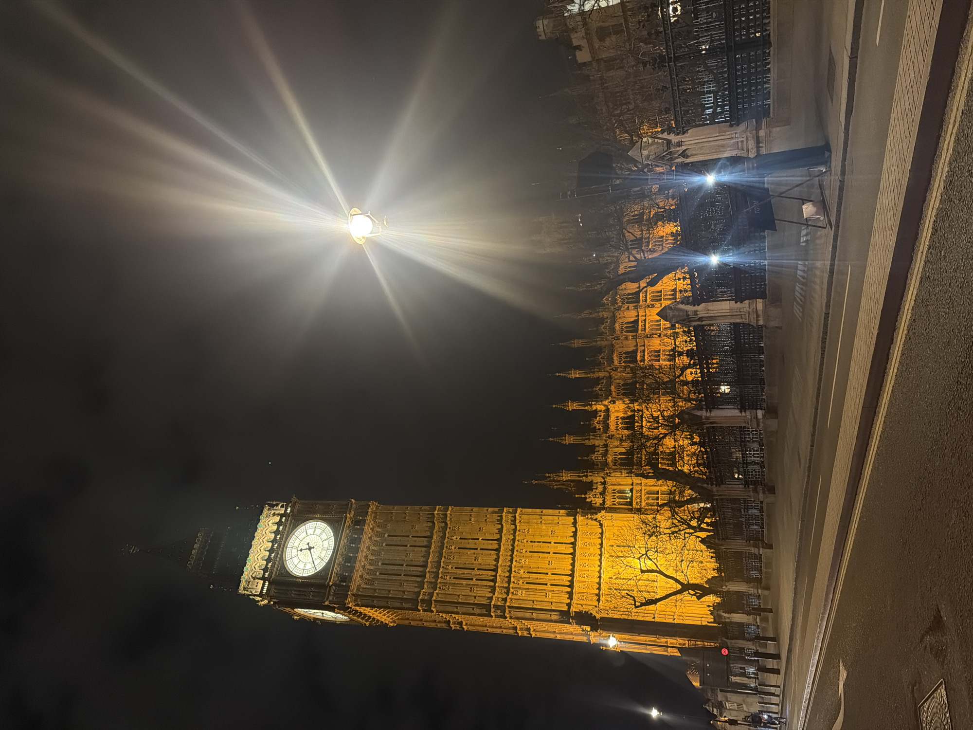 Big Ben illuminated at night as London traffic passes