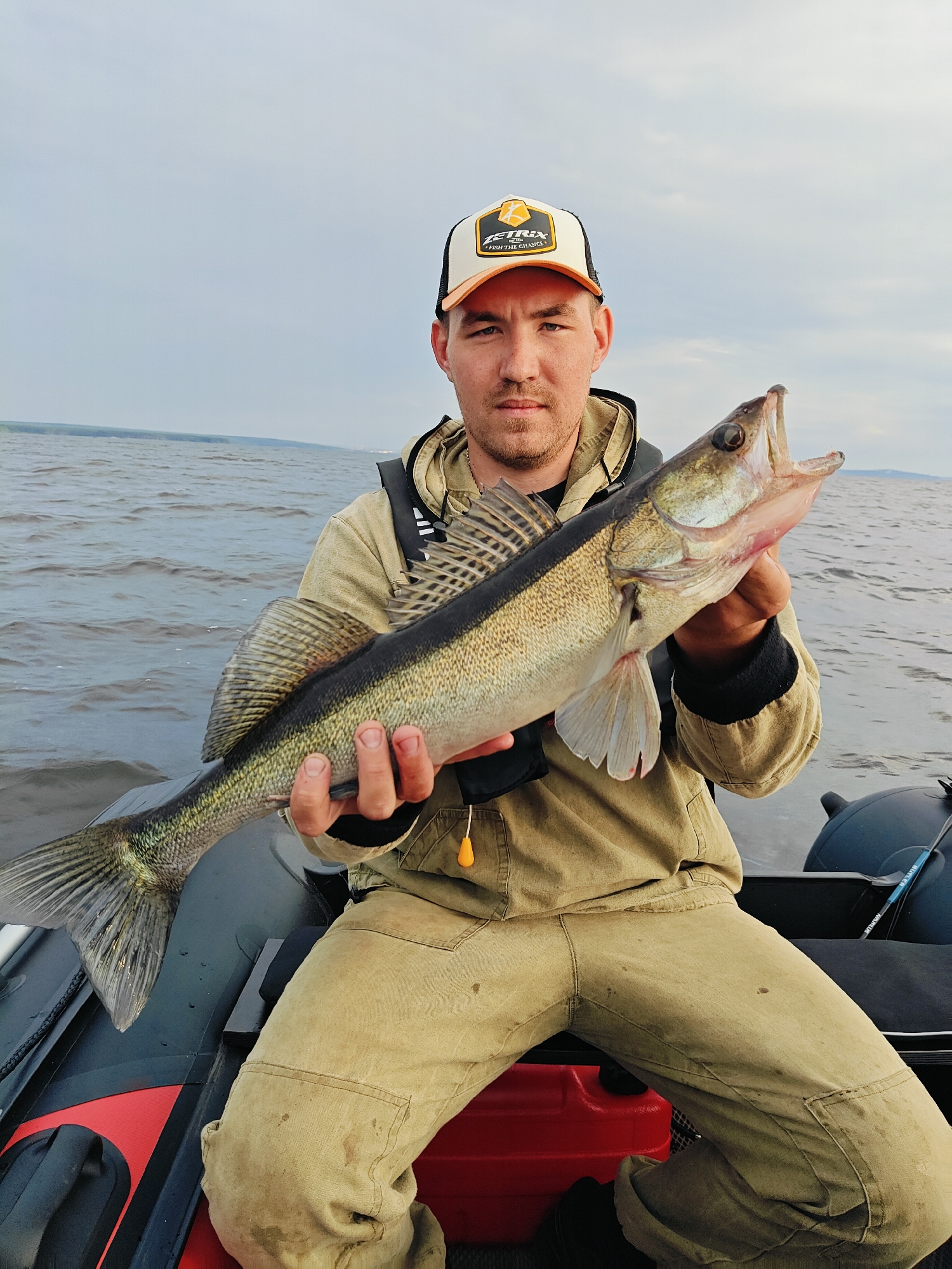 A solid catch from an inflatable boat on overcast Russian waters.