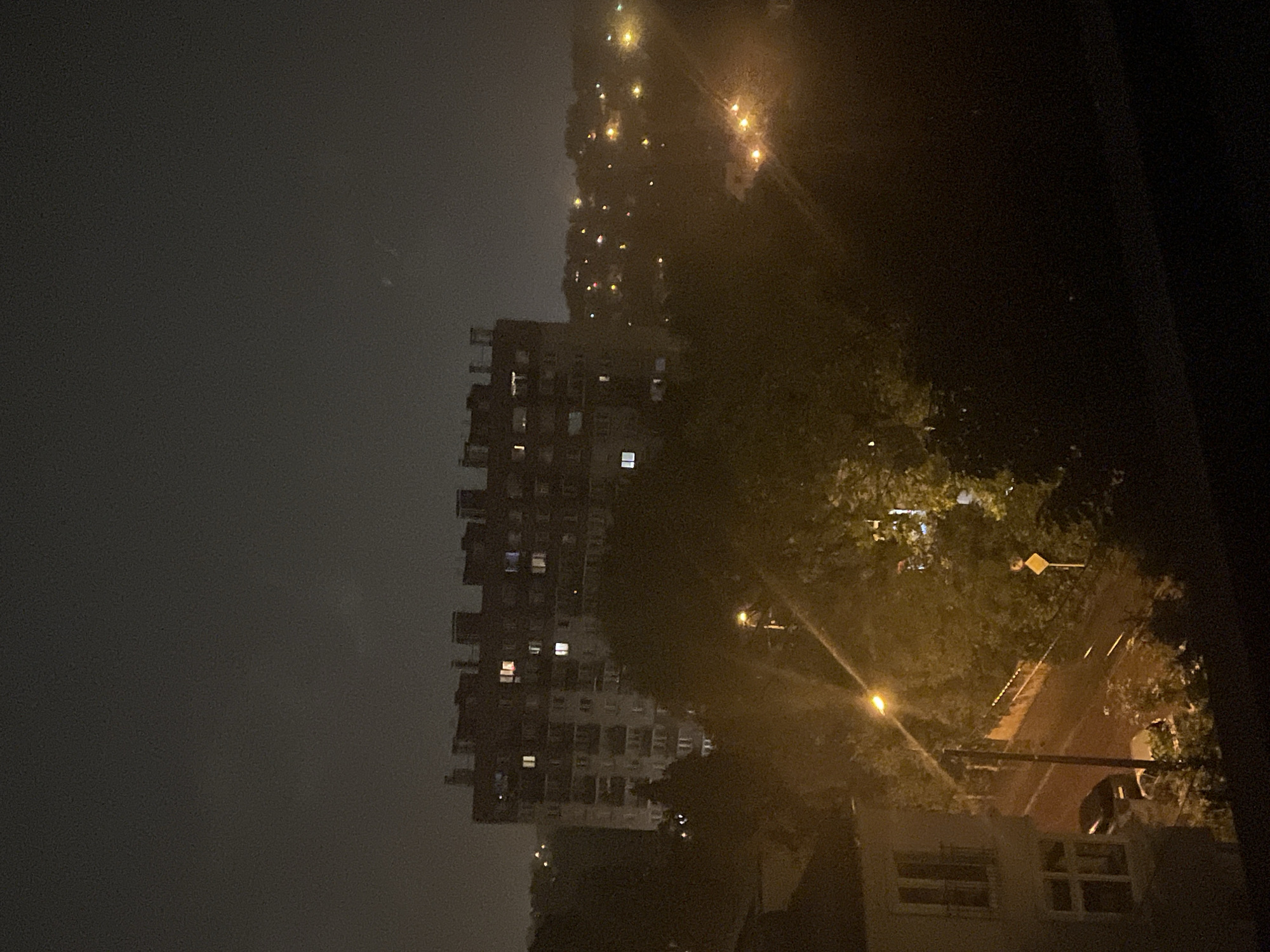 Rainy night cityscape from balcony vantage point