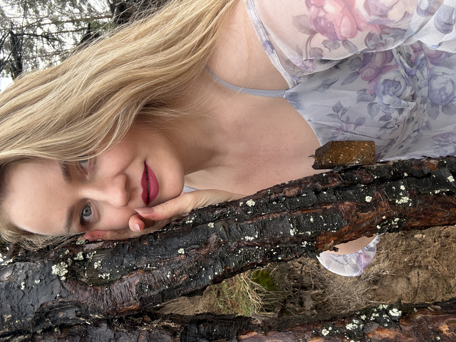 Woman poses for outdoor portraits among tree roots in Chaikovsky