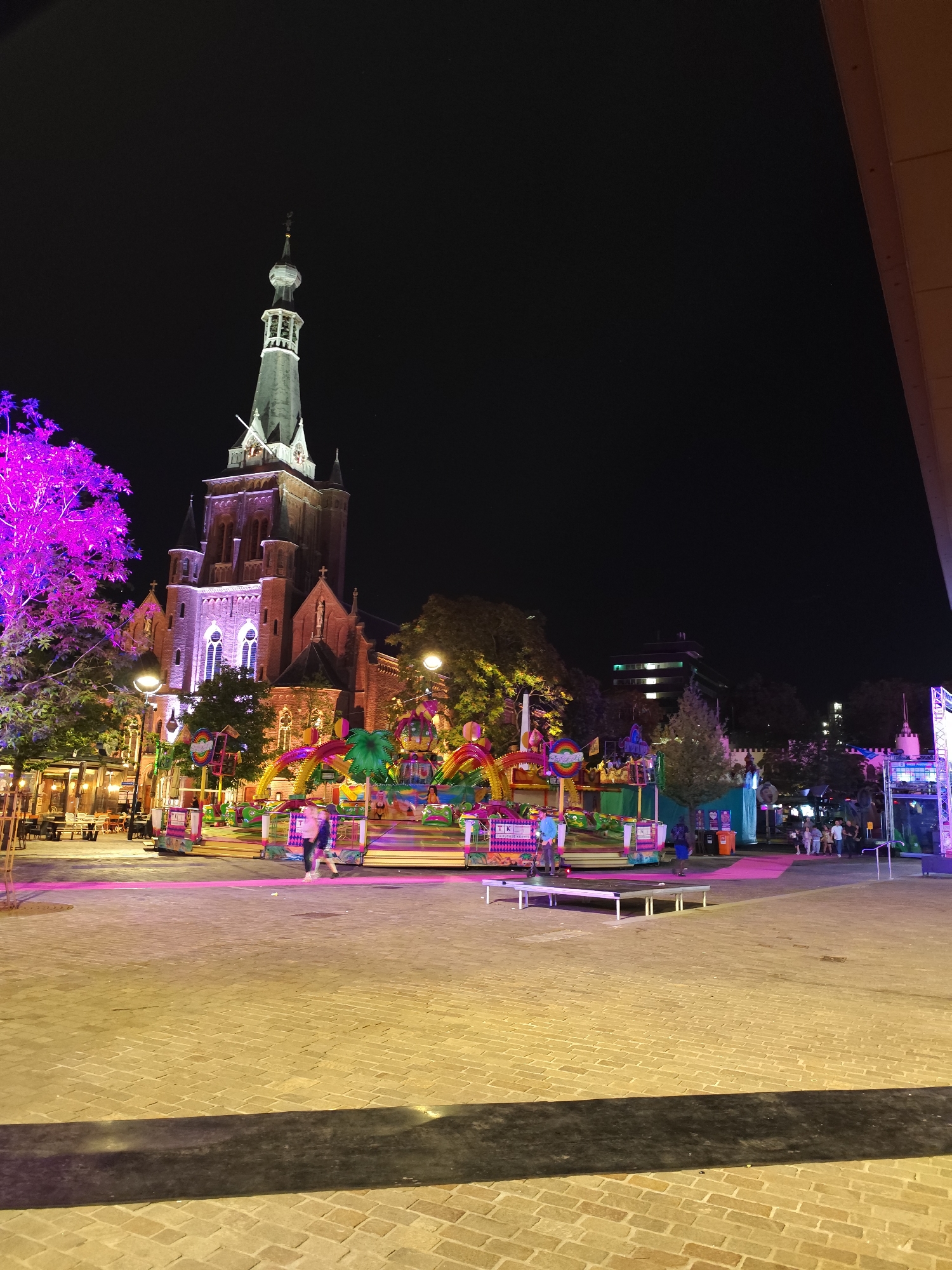 Night-time carnival lights blur across central Tilburg