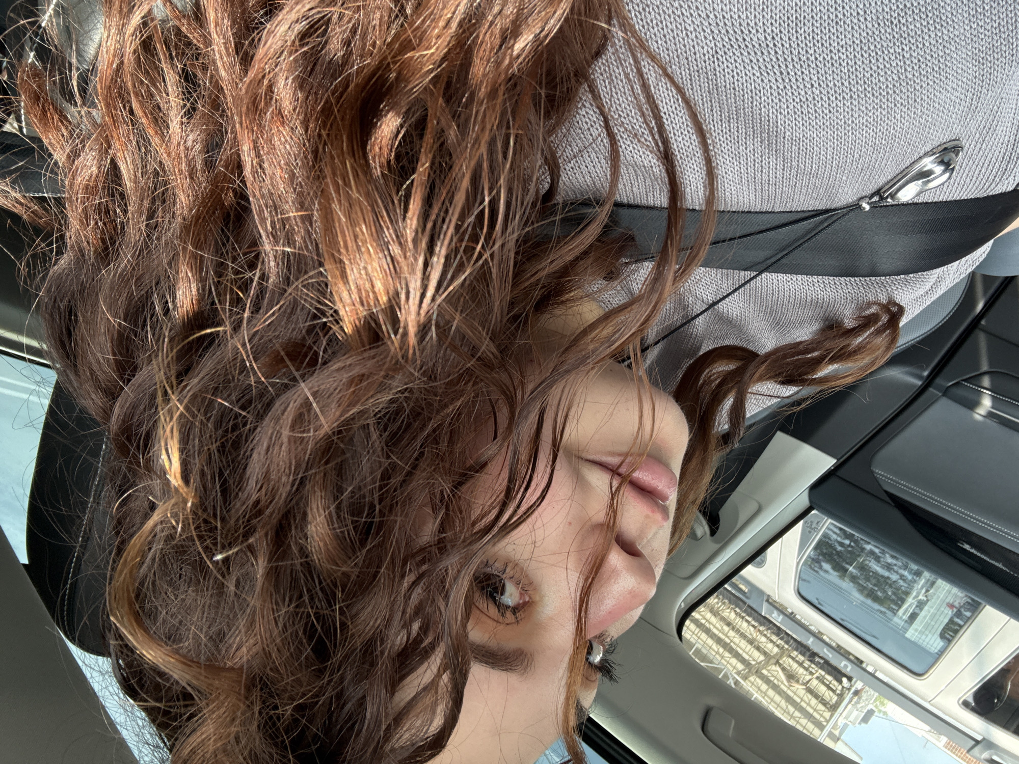 Woman rests in car during evening hours in Mexico City