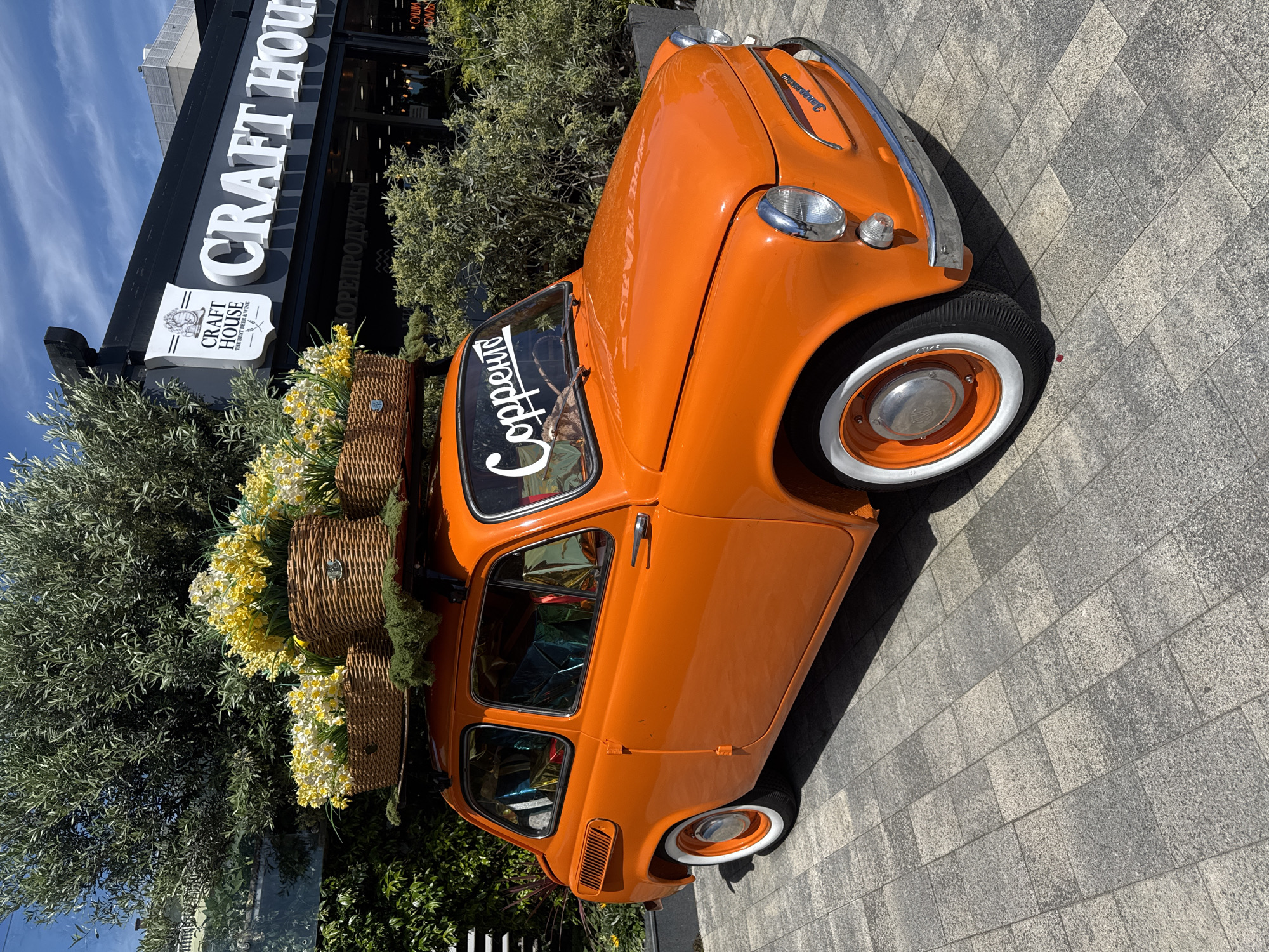 Woman photographs vintage orange car, selfies in Sochi