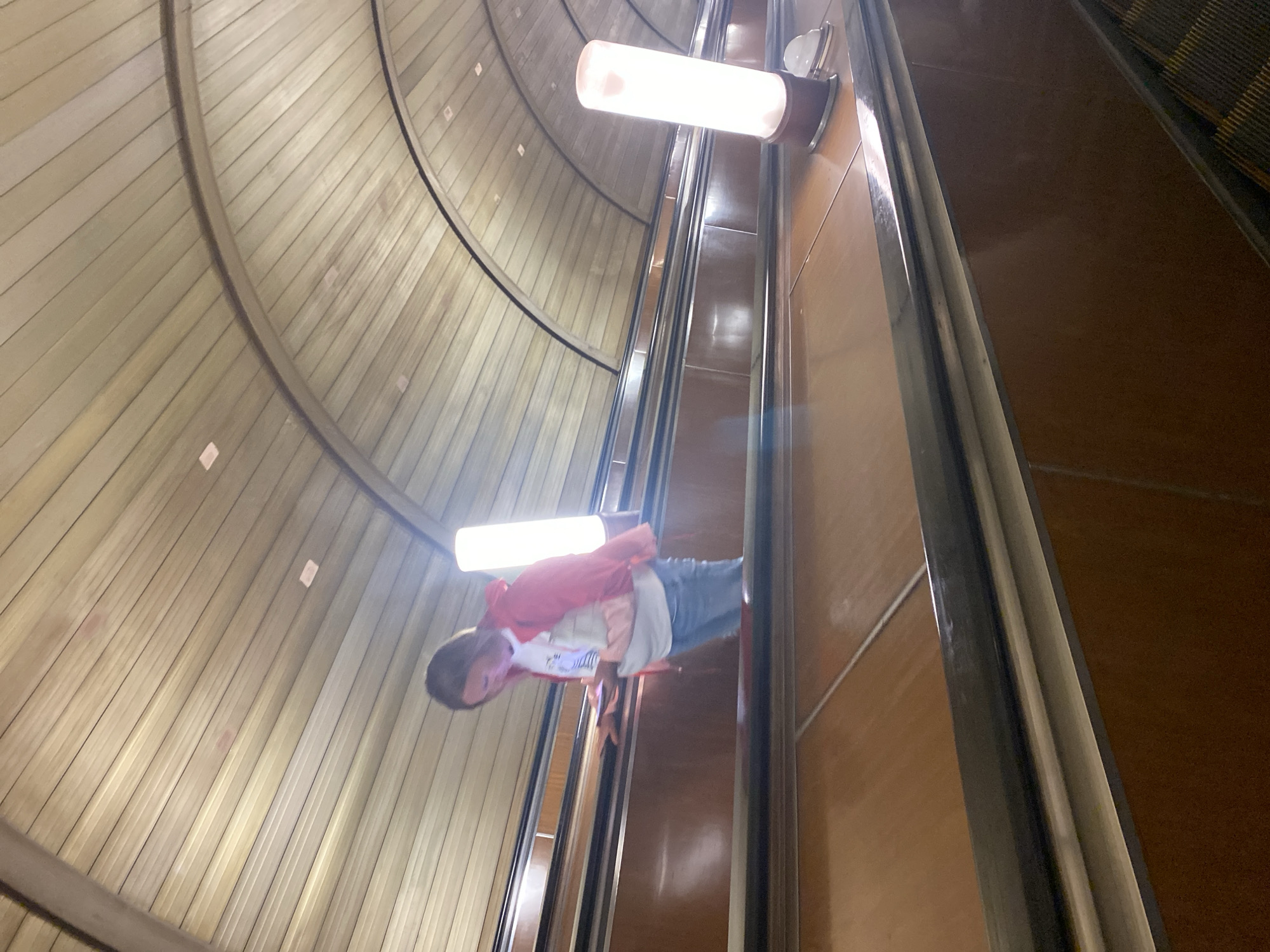 Inside a metro station escalator tunnel, Cyrillic signage visible