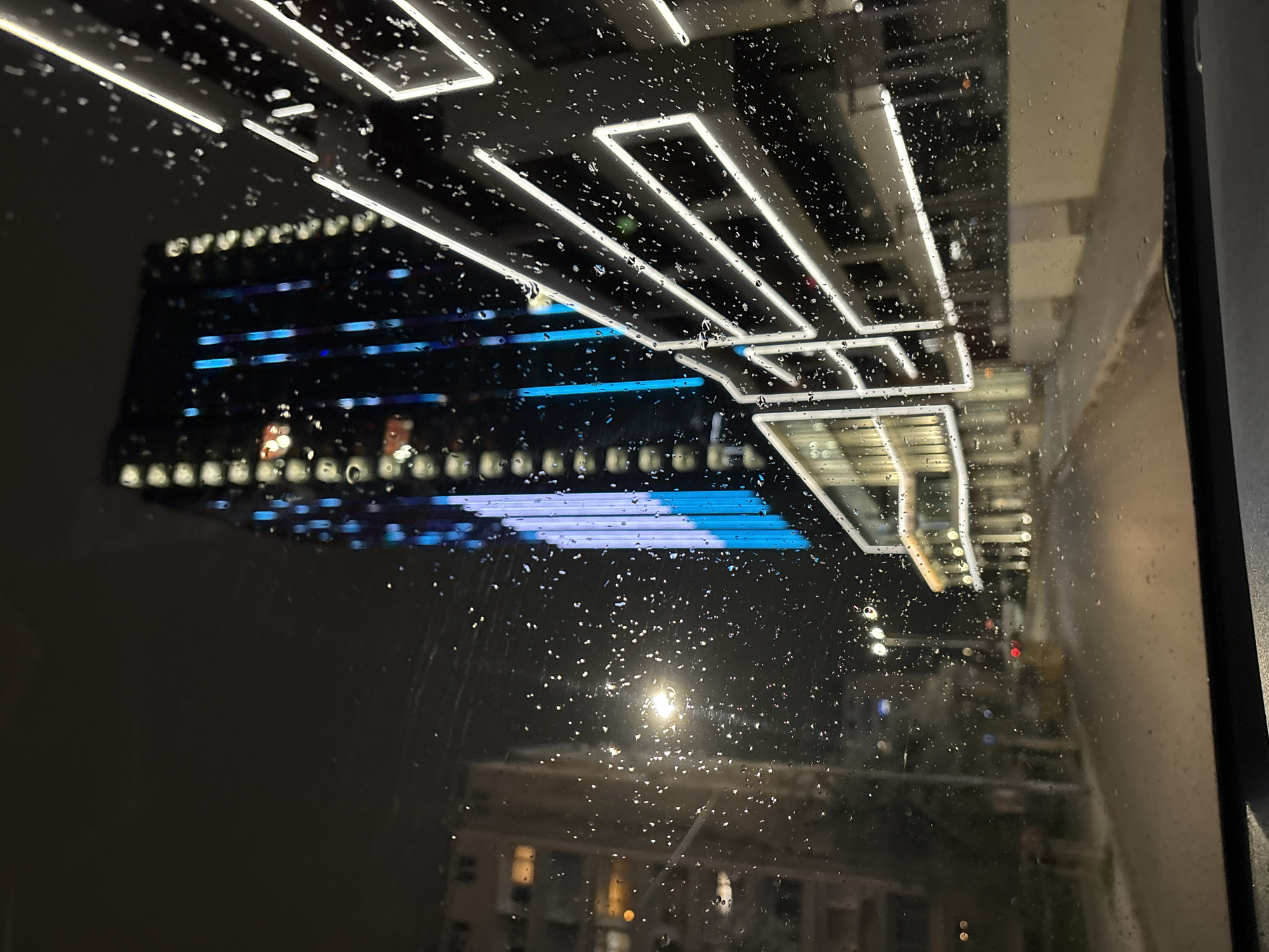 Rainy night view of illuminated modern building in Sofia