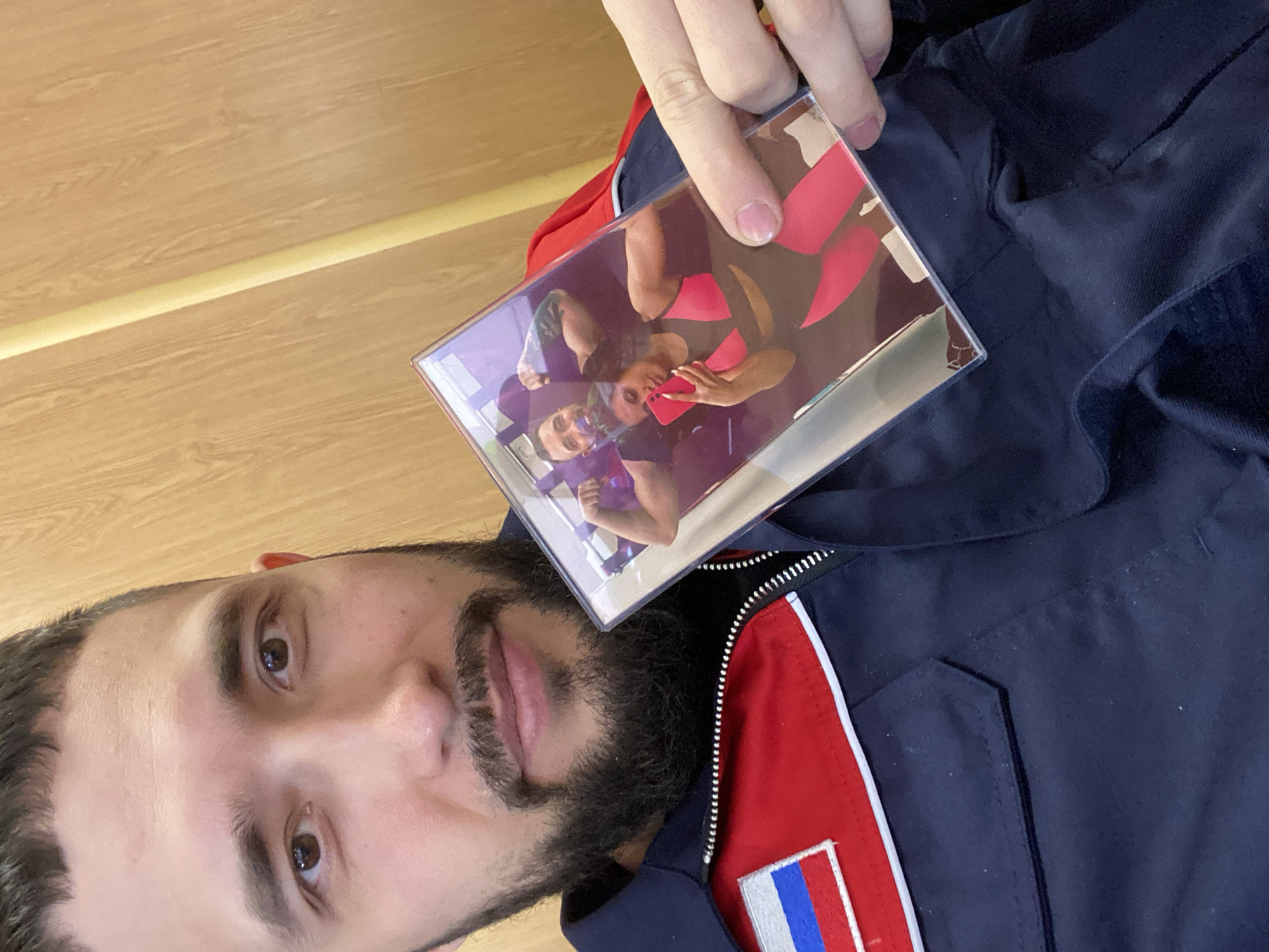 Man with Russian flag jacket holds photo in Luzhitsy