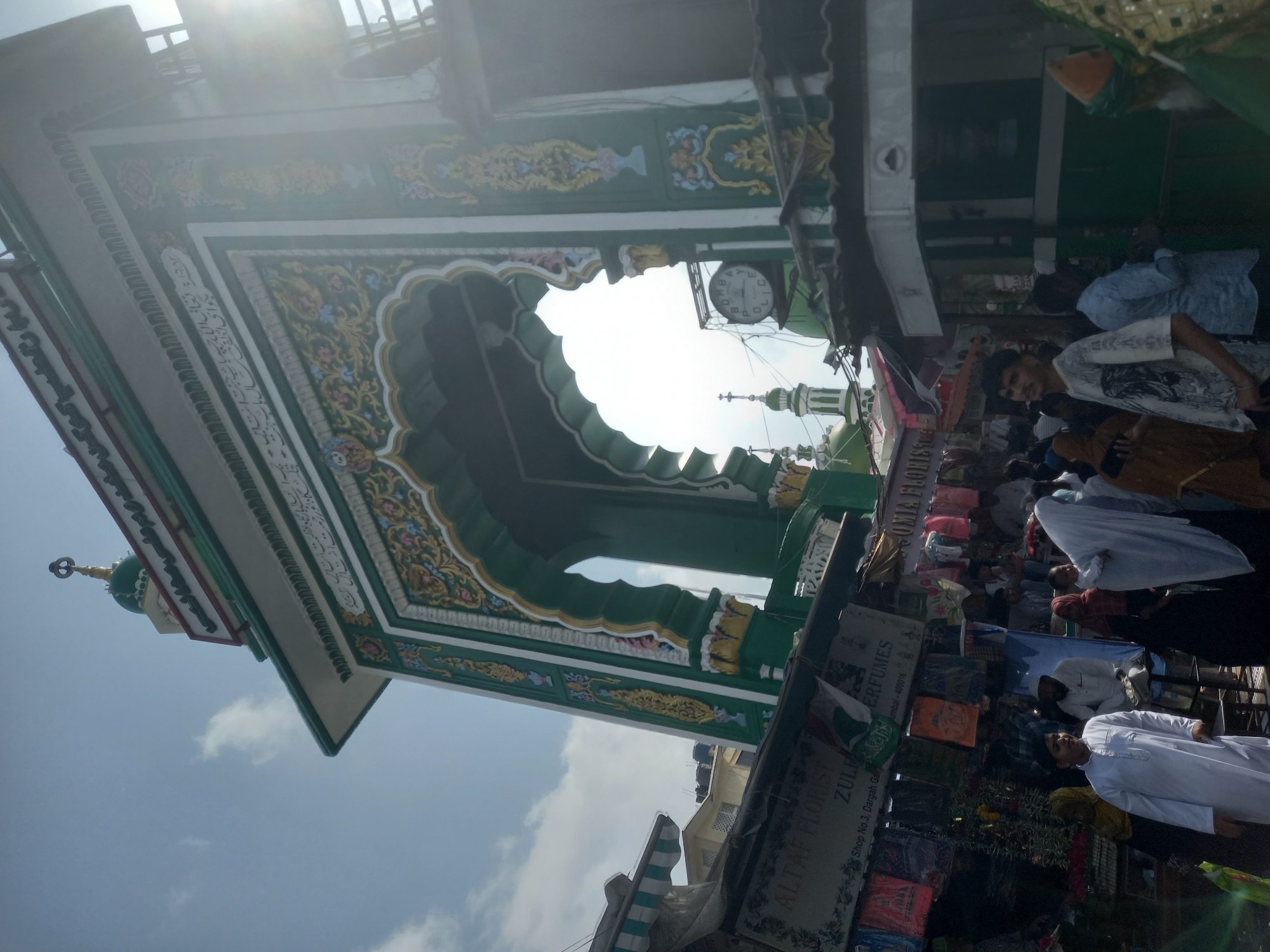 Ornate archway observed at bustling Mumbai market near religious site
