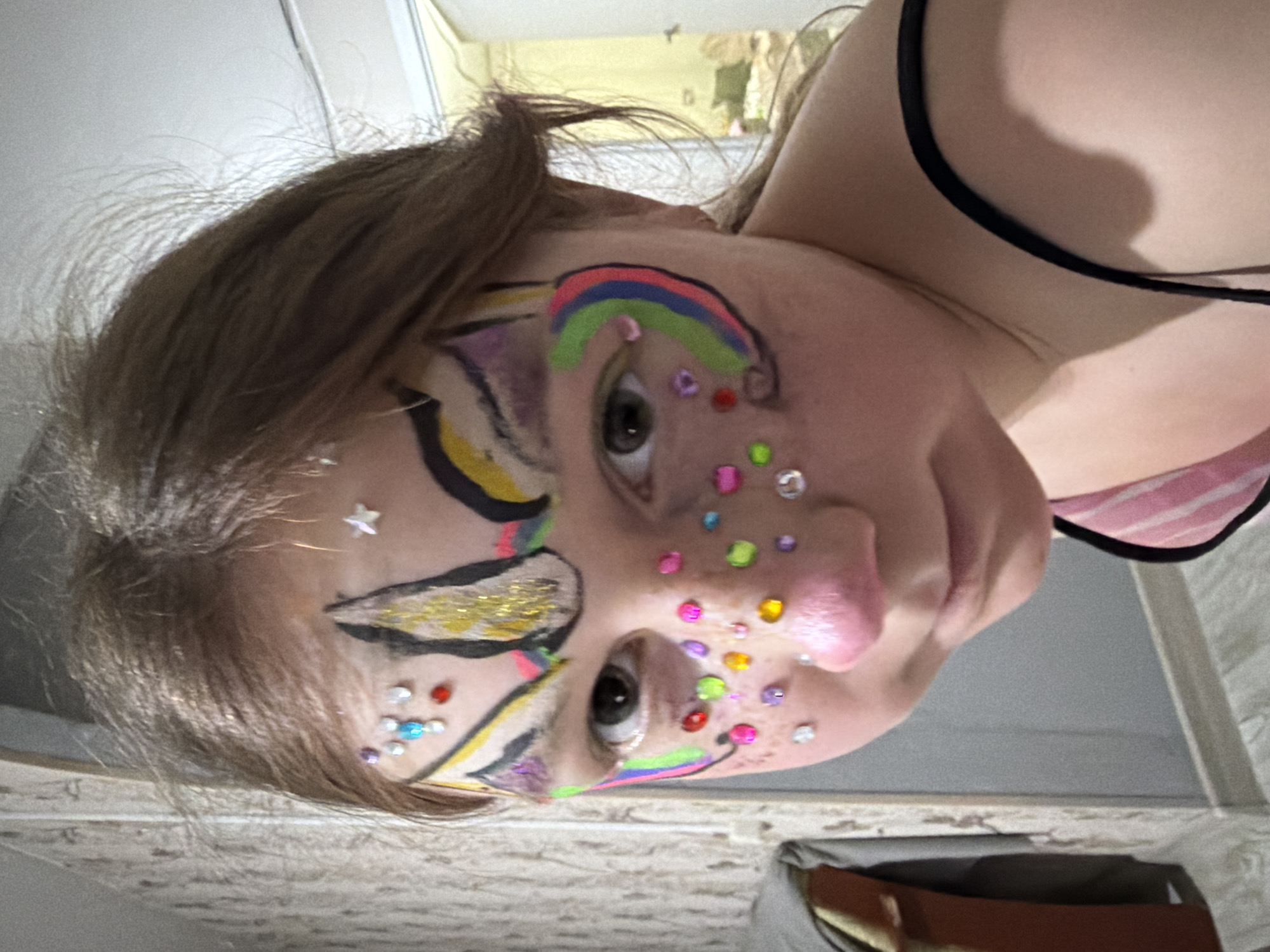 Family gathering with face-painted child around fireplace in Markovo