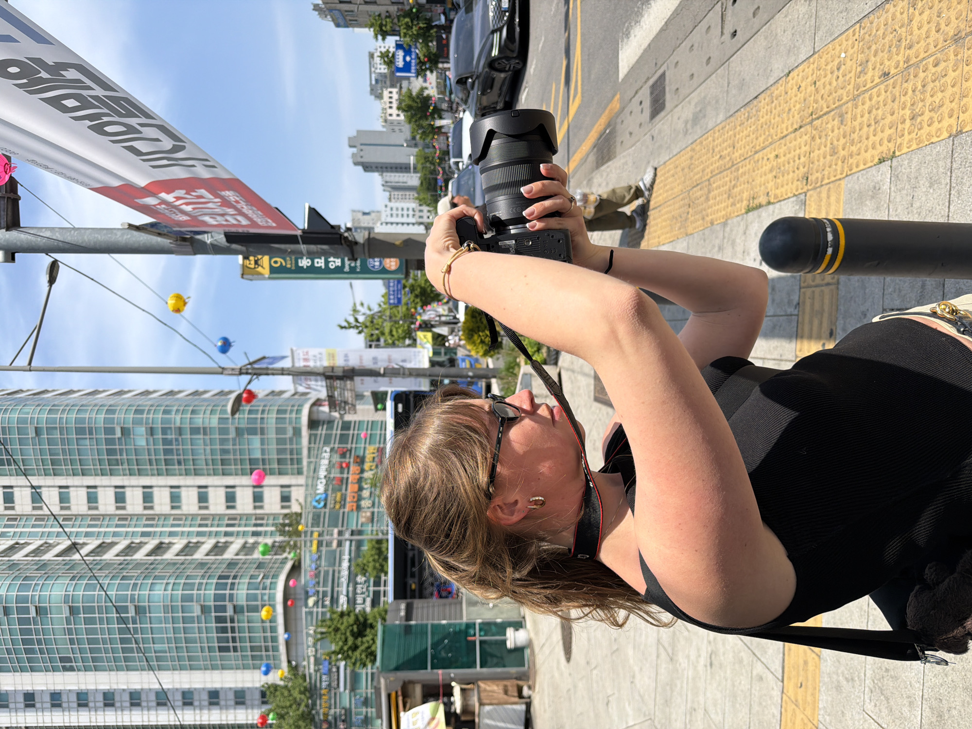 Woman photographs Seoul street scene in early morning hours
