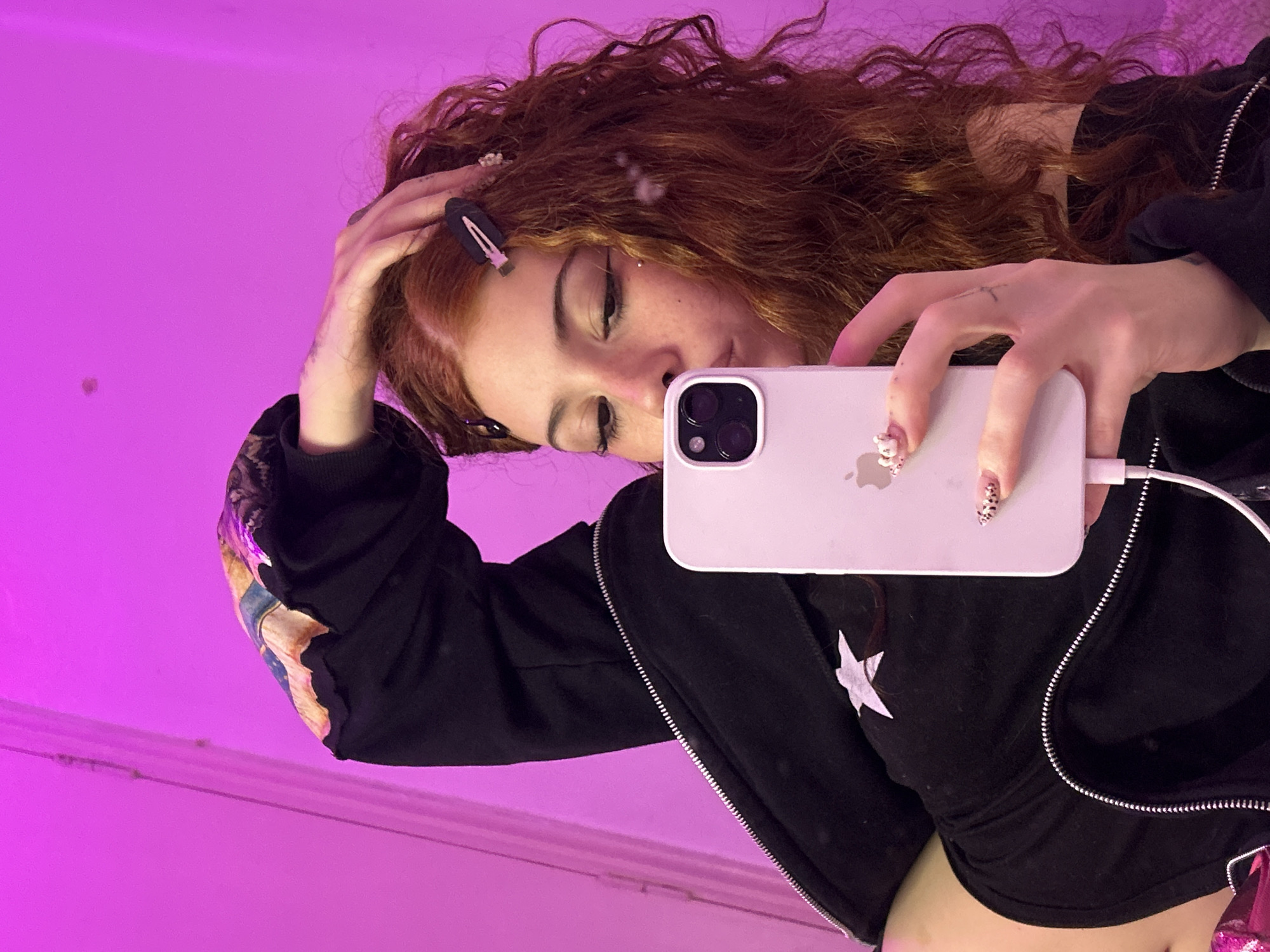 Woman takes selfie in pink-lit indoor space, Buenos Aires