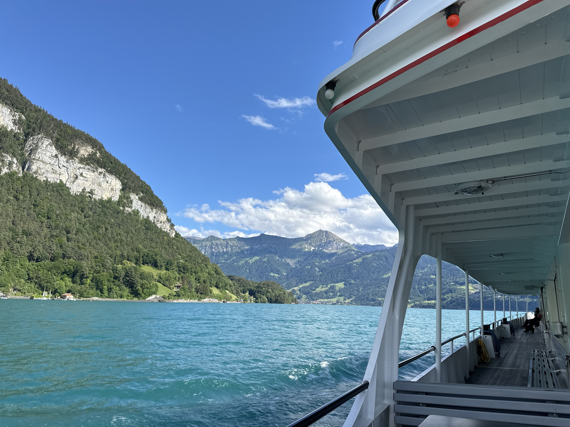 Ferry crosses turquoise Lake Thun near Merligen, Switzerland