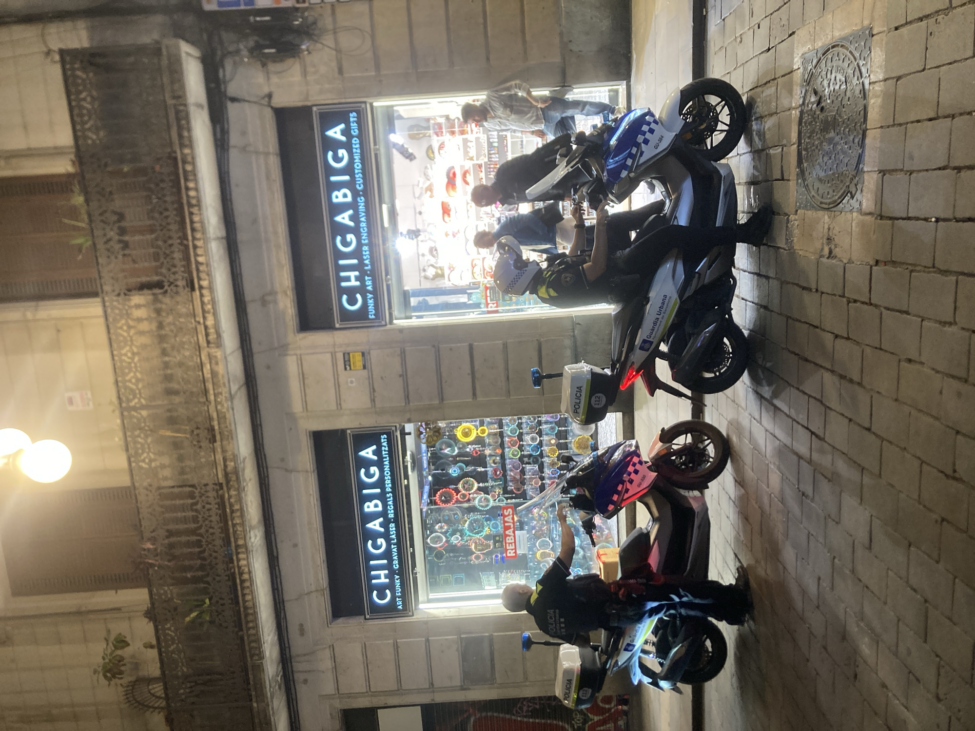 Police patrol outside Barcelona art shop on summer evening