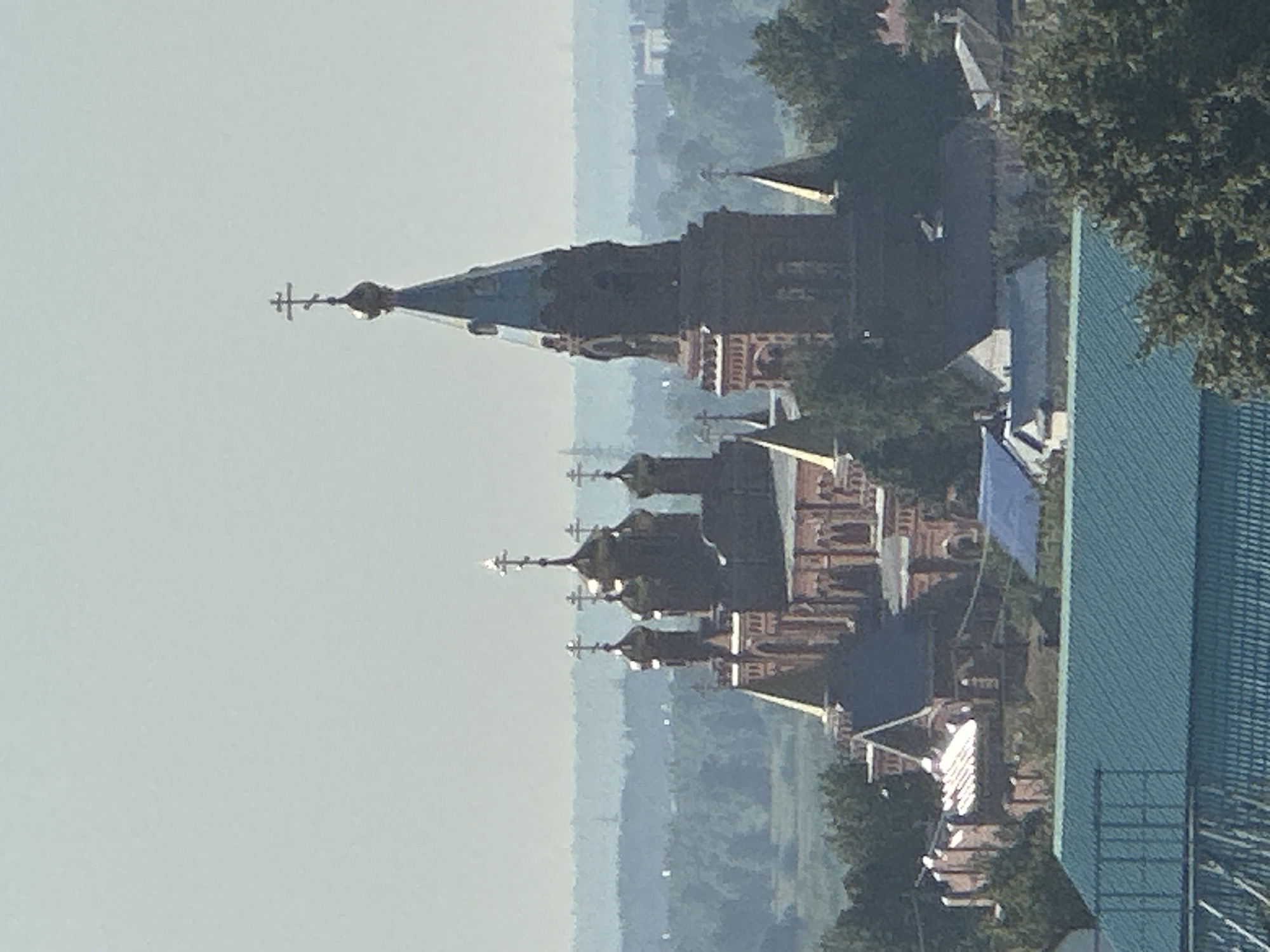 Red brick Orthodox church with golden domes overlooking a city